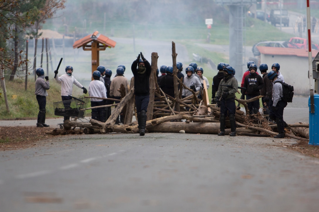 A road block is set up by role-playing rioters during crowd and riot control training being conducted by U.S. Marines with SPMAGTF Crisis Response – Africa and French gendarmes with Mobile Gendarmeries Armored Group at the National Gendarmerie Training Center in St. Astier, France, Dec. 3, 2014. The exercise allowed the Marines to gain greater knowledge of non-lethal tactics, techniques and procedures while enhancing interoperability with the French Gendarmerie and strengthening the U.S. partnership with France. (U.S. Marine Corps photo by Cpl Jeraco Jenkins/Released).