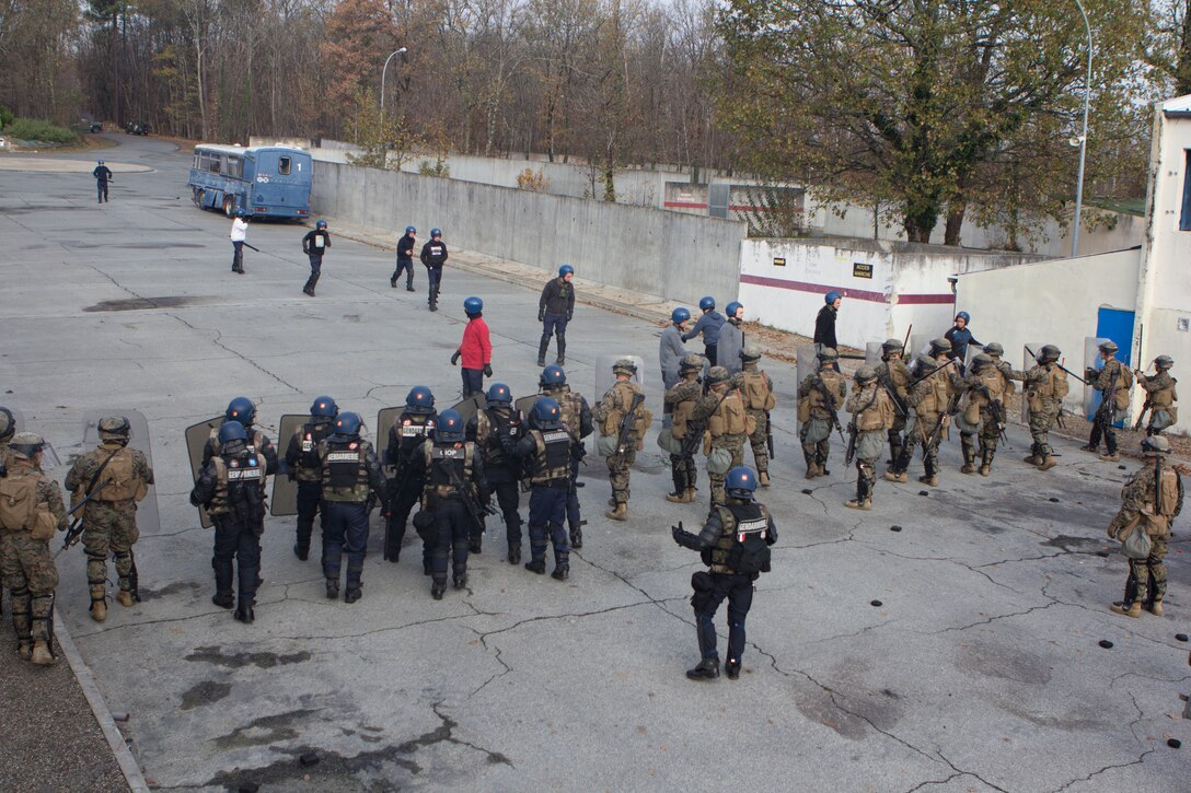 U.S. Marines with SPMAGTF Crisis Response – Africa and French gendarmes with Mobile Gendarmeries Armored Group are taunted by role-playing rioters during crowd and riot control techniques training at the National Gendarmerie Training Center in St. Astier, France, Dec. 3, 2014. The exercise allowed the Marines to gain greater knowledge of non-lethal tactics, techniques and procedures while enhancing interoperability with the French Gendarmerie and strengthening the U.S. partnership with France. (U.S. Marine Corps photo by Cpl Jeraco Jenkins/Released)