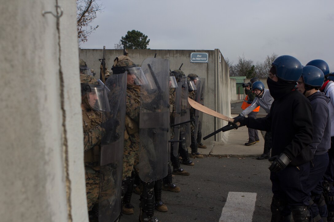 U.S. Marines with SPMAGTF Crisis Response – Africa are taunted by role-playing rioters during crowd and riot control techniques training at the National Gendarmerie Training Center in St. Astier, France, Dec. 3, 2014. The exercise allowed the Marines to gain greater knowledge of non-lethal tactics, techniques and procedures while enhancing interoperability with the French Gendarmerie and strengthening the U.S. partnership with France. (U.S. Marine Corps photo by Cpl Jeraco Jenkins/Released)