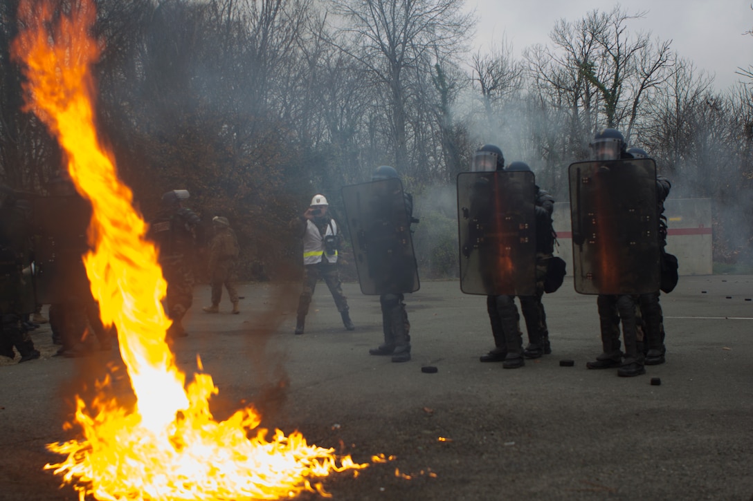 A Molotov cocktail, thrown by Mock rioters played by fire fighters, explodes in front of U.S. Marines with SPMAGTF Crisis Response – Africa and French gendarmes with Mobile Gendarmeries Armored Group, as they train in crowd and riot control techniques at the National Gendarmerie Training Center in St. Astier, France, Dec. 2, 2014. The exercise allowed the Marines to gain greater knowledge of non-lethal tactics, techniques and procedures while enhancing interoperability with the French Gendarmerie and strengthening the U.S. partnership with France. (U.S. Marine Corps photo by Cpl Jeraco Jenkins/Released)