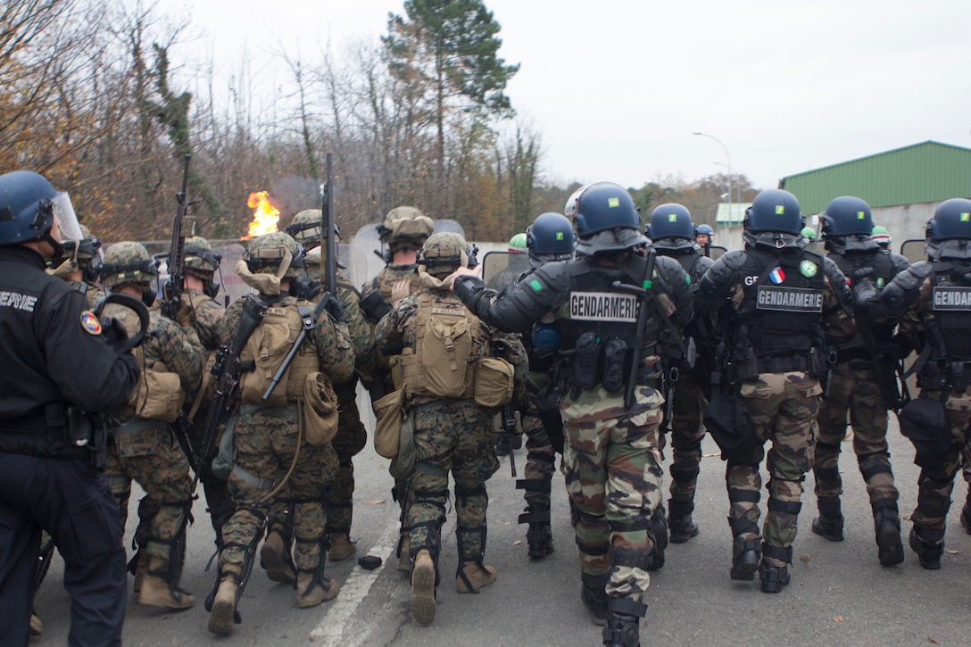 U.S. Marines with SPMAGTF Crisis Response – Africa and French gendarmes with Mobile Gendarmeries Armored Group work together to control a mock riot caused by role-players, while training in crowd and riot control techniques at the National Gendarmerie Training Center in St. Astier, France, Dec. 2, 2014. The exercise allowed the Marines to gain greater knowledge of non-lethal tactics, techniques and procedures while enhancing interoperability with the French Gendarmerie and strengthening the U.S. partnership with France. (U.S. Marine Corps photo by Cpl Jeraco Jenkins/Released)