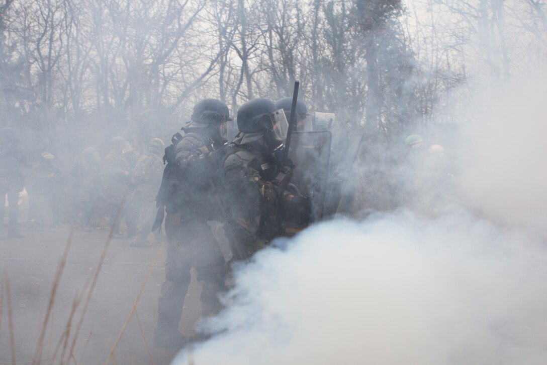 U.S. Marines with SPMAGTF Crisis Response – Africa march though tear gas during crowd and riot control technique practice techniques at the National Gendarmerie Training Center in St. Astier, France, Dec. 2, 2014. The exercise, which was conducted with the French Gendarmerie, allowed the Marines to gain greater knowledge of non-lethal tactics, techniques and procedures while enhancing interoperability with the French Gendarmerie and strengthening the U.S. partnership with France.  (U.S. Marine Corps photo by Cpl Jeraco Jenkins/Released)