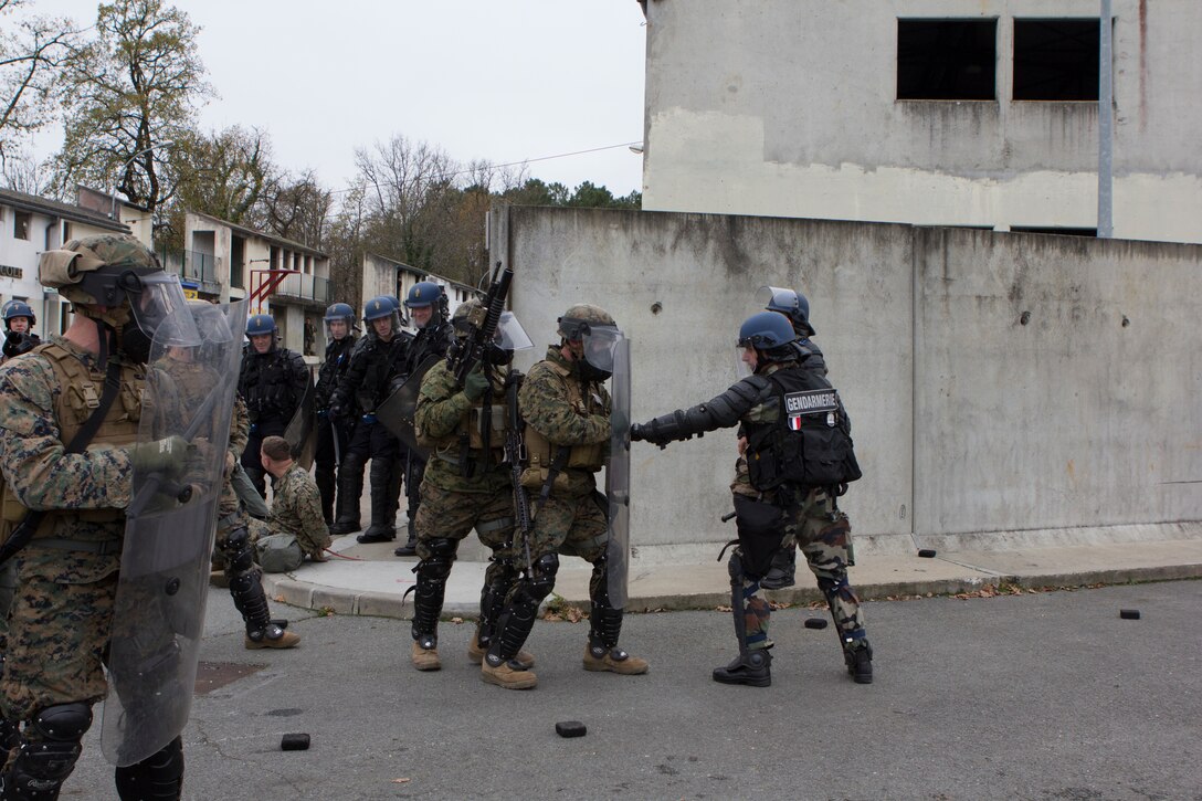 French Gendarmes with Mobile Gendarmeries Armored Group role-play as rioters while U.S. Marines with SPMAGTF-CR-AF train in crowd and riot control techniques at the National Gendarmerie Training Center in St. Astier, France, Dec. 2, 2014.  The exercise, which was conducted with the French Gendarmerie, allowed the Marines to gain greater knowledge of non-lethal tactics, techniques and procedures while enhancing interoperability with the French Gendarmerie and strengthening the U.S. partnership with France.  (U.S. Marine Corps photo by Cpl. Jeraco Jenkins/Released)