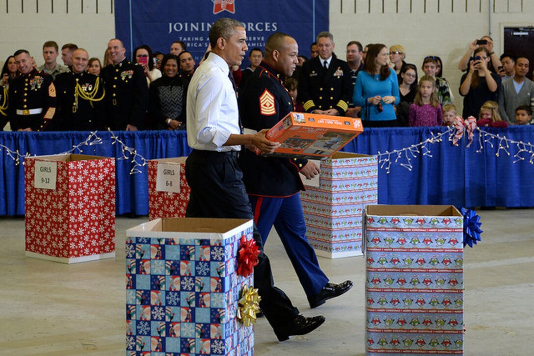 President Barack Obama and a Marine begin sorting toys by age group during an event supporting the U.S. Marine Corps Reserve Toys for Tots Program at Joint Base Anacostia-Bolling in Washington, D.C. Dec. 10, 2014. The president exaggerated his reaction for children in the audience. 