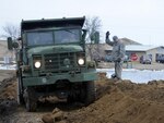 Staff Sgt. Benji Boll directs a quick response force dump truck into place so that it can unload dike building material in Lidgerwood, N.D., March 18, 2010. The North Dakota Army National Guard truck is being driven by Sgt. Tracy K. Muller. The QRF personnel and equipment from the 188th Engineer Company in Wahpeton, N.D., quickly responded to the emergency request for help in Lidgerwood.