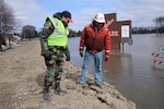 Staff Sgt. Wayne Baumbach, of the 119th Communications Flight, points out a possible problem area in a clay dike to Kevin Ressie, of the Army Corp of Engineers (St. Paul office), March 19, Fargo, N.D. Baumbach is a North Dakota Air National Guard flood dike walker, who is tasked with watching the flood dikes for possible problems and also to keep people from climbing up on the dikes. Ressie is responsible for construction and maintenance of the flood dikes.