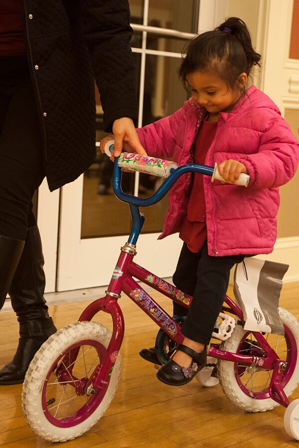 Lia Lujano, 3, rides the bike she won in a holiday raffle during the 22nd Marine Expeditionary Unit (MEU) Christmas party Dec. 10, 2014, at Marine Corps Base Camp Lejeune, N.C. (U.S. Marine Corps photo by Sgt. Austin Hazard/Released)