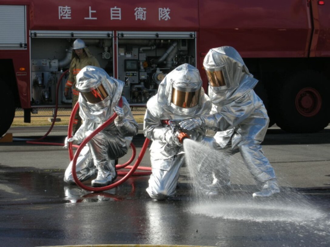 21 Nov 2014, Shizuoka prefecture, Camp Fuji, Japan - Members of the Camp Fuji Fire Department build rapport and increase interoperability by conducting live fire-fighting training and helicopter bucket operation training with members of the Japan Ground Self Defense Force Camp Fuji Aviation Detachment.
