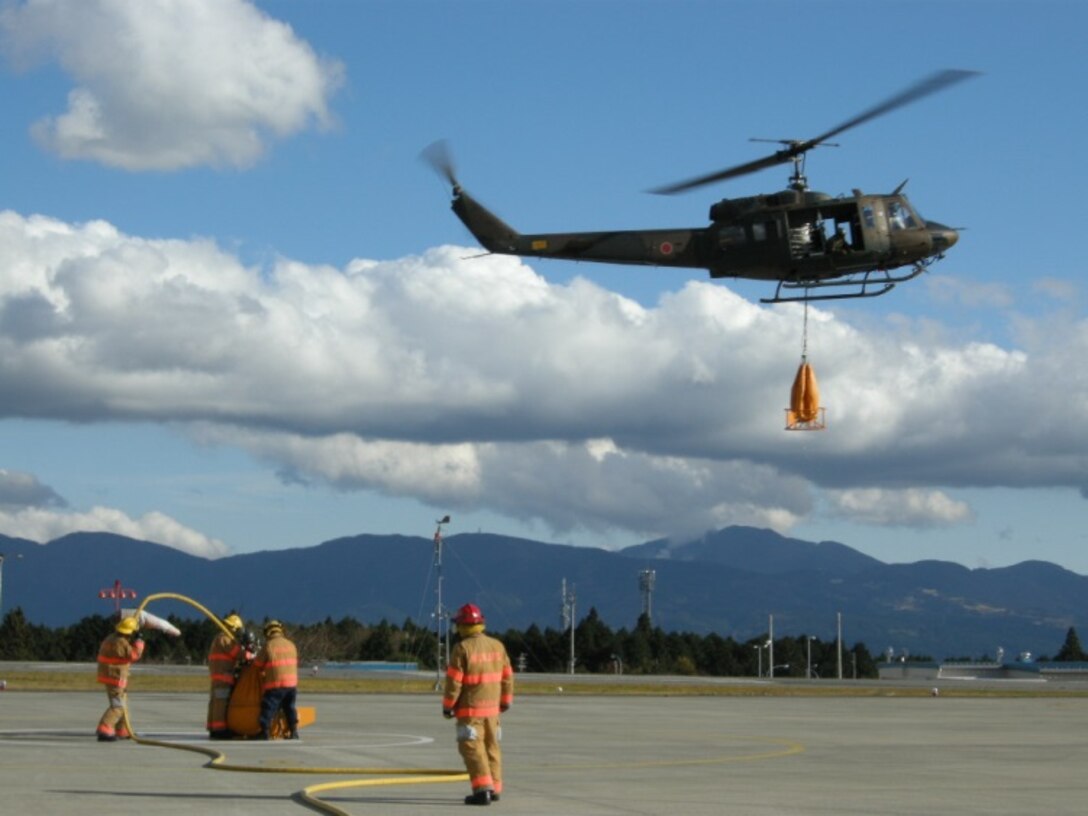 21 Nov 2014, Shizuoka prefecture, Camp Fuji, Japan - Members of the Camp Fuji Fire Department build rapport and increase interoperability by conducting live fire-fighting training and helicopter bucket operation training with members of the Japan Ground Self Defense Force Camp Fuji Aviation Detachment.
