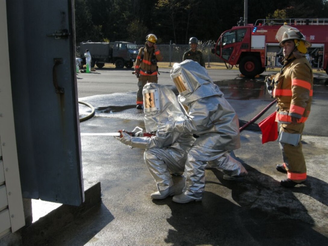 21 Nov 2014, Shizuoka prefecture, Camp Fuji, Japan - Members of the Camp Fuji Fire Department build rapport and increase interoperability by conducting live fire-fighting training and helicopter bucket operation training with members of the Japan Ground Self Defense Force Camp Fuji Aviation Detachment.