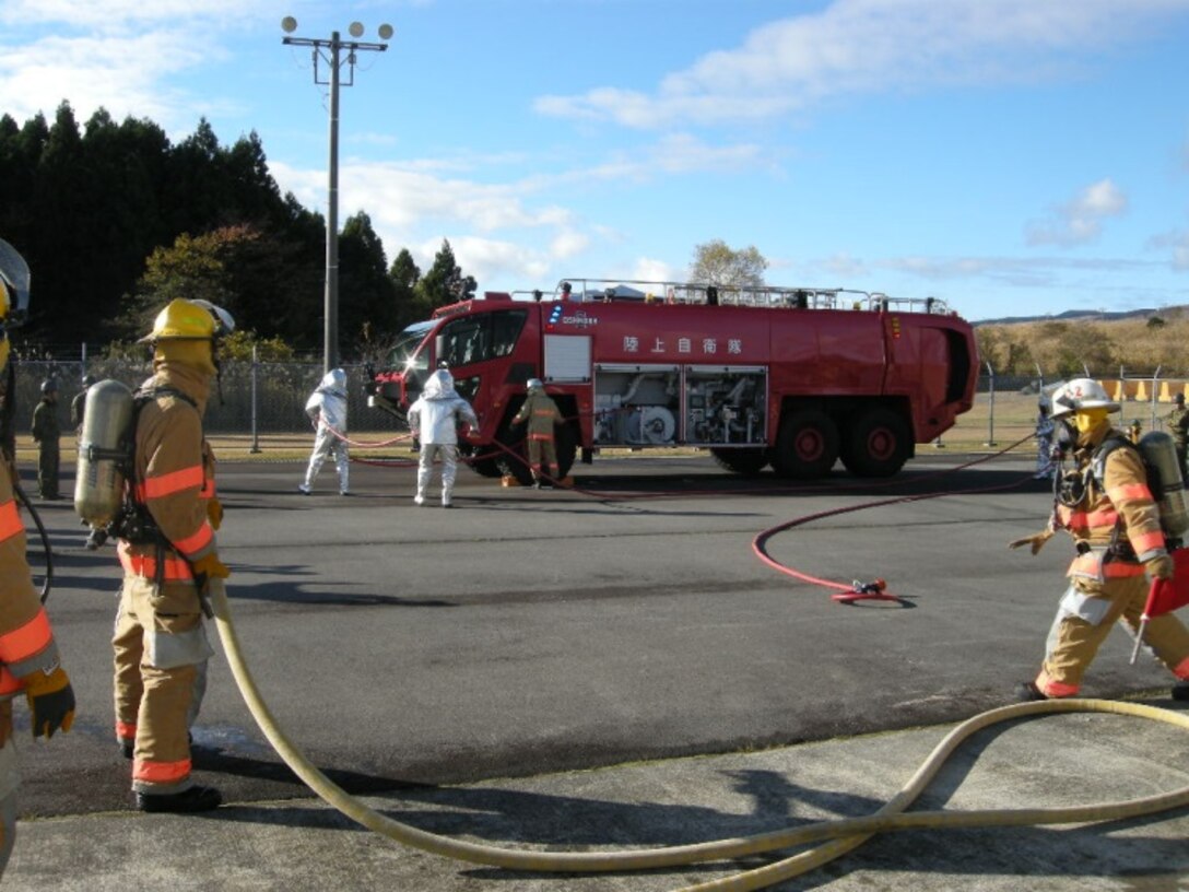 21 Nov 2014, Shizuoka prefecture, Camp Fuji, Japan - Members of the Camp Fuji Fire Department build rapport and increase interoperability by conducting live fire-fighting training and helicopter bucket operation training with members of the Japan Ground Self Defense Force Camp Fuji Aviation Detachment.