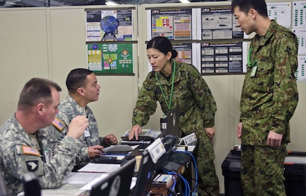 CAMP ASAKA, Japan (Dec. 11, 2014) - Chief Warrant Officer 3 Onix Vazquez, a petroleum system technician with the 593rd Expeditionary Sustainment Command, works with members of the Japan Ground Self-Defense Force during Yama Sakura, an annual bilateral command post exercise between Japan and the U.S. The exercise ran from Dec. 2-14 on Camp Asaka. 
