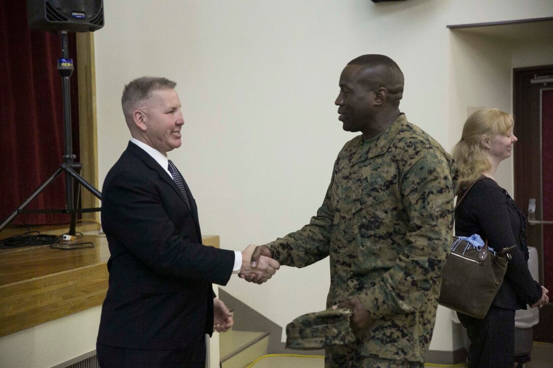 Justin Constantine, left, shakes hands with Chief Warrant Officer Edwin C. Bates after Constantine’s presentation Dec. 4 at Camp Kinser. Constantine, who suffered a traumatic brain injury during combat in Iraq, shares his story of recovery to spread awareness about post-traumatic stress and encourage Marines to not be afraid to seek help. Constantine is from Arlington, Virginia, and is a retired Marine lieutenant colonel who now gives inspirational presentations. Bates is from Alexandria, Louisiana, and is the executive officer for Food Service Company, Headquarters Regiment, 3rd Marine Logistics Group, III Marine Expeditionary Force. 