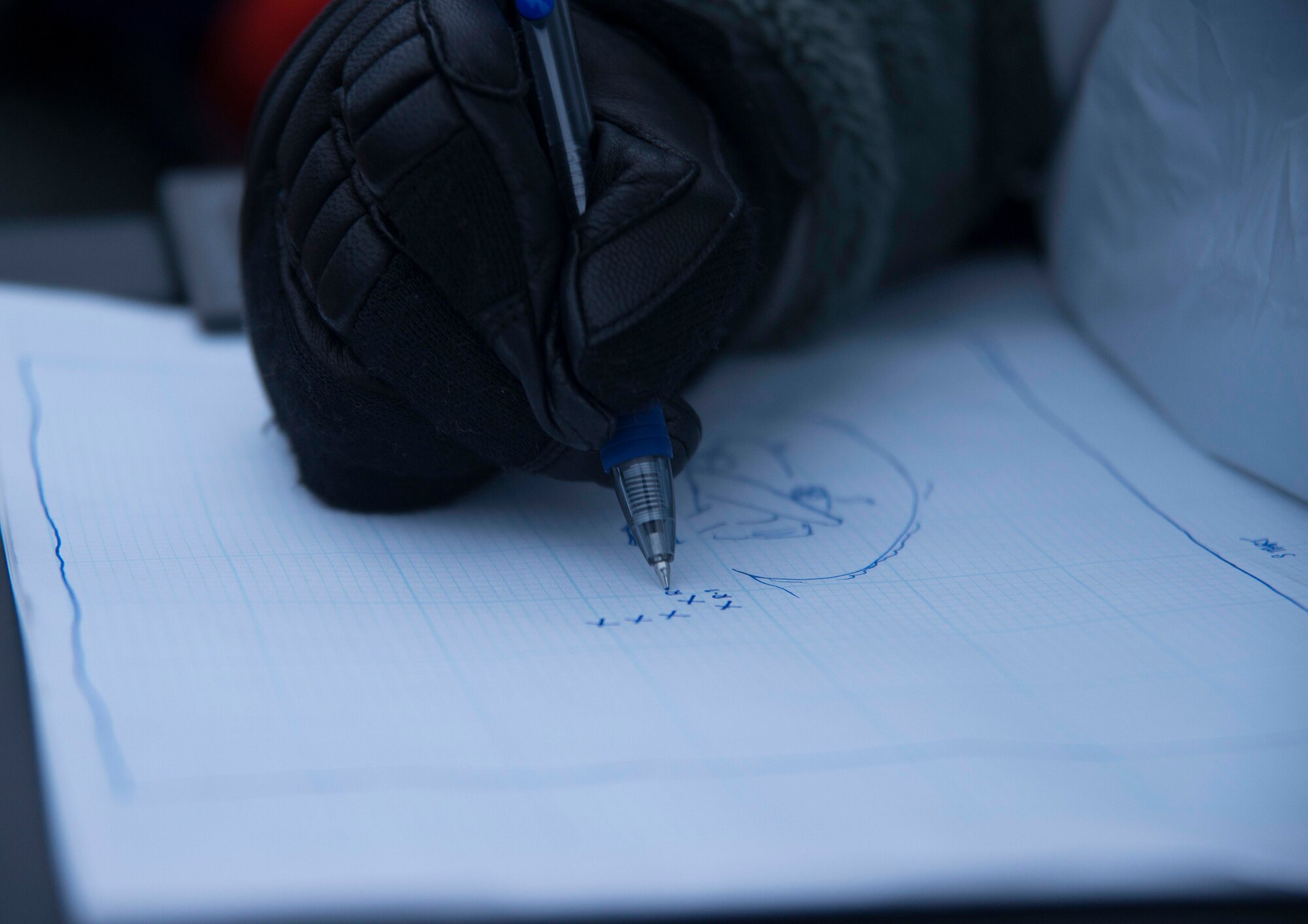 An Airman from the 35th Force Support Squadron sketches a recovery layout plan at the scene of a simulated C-130 Hercules crash scene at Misawa Air Base, Japan, Dec. 10, 2014. Nine Airmen performed a search and recovery mission in support of exercise Beverly Sunrise 15-1. (U.S. Air Force photo by Staff Sgt. Derek VanHorn/Released)