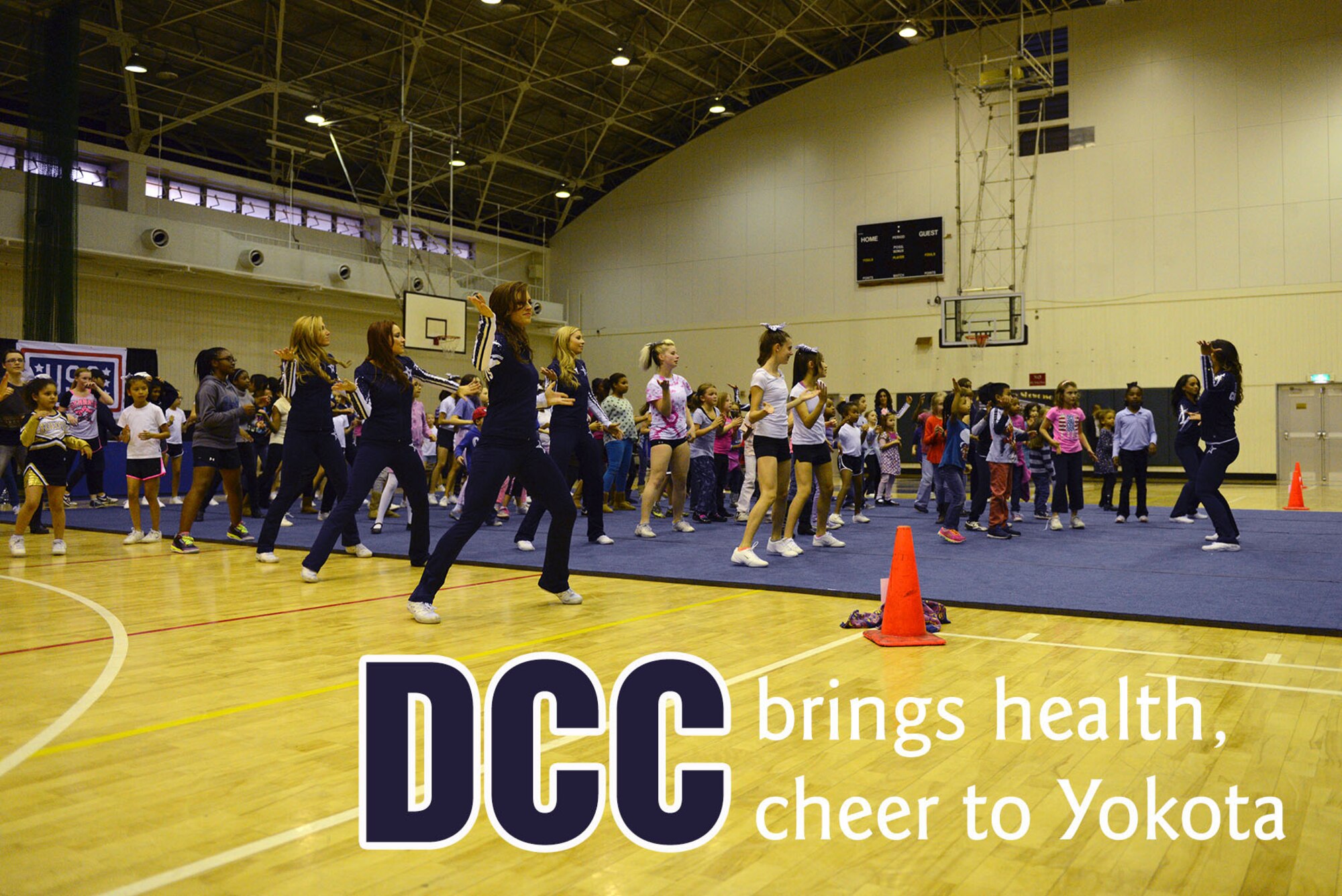 Dallas Cowboys Cheerleaders and youth from Yokota Air Base, Japan, participate in a group fitness routine Dec. 9, 2014. The cheerleaders taught the youth about the importance of being healthy and exercising for at least 30 minutes a day. (U.S. Air Force photo by Senior Airman Desiree Economides/Released)