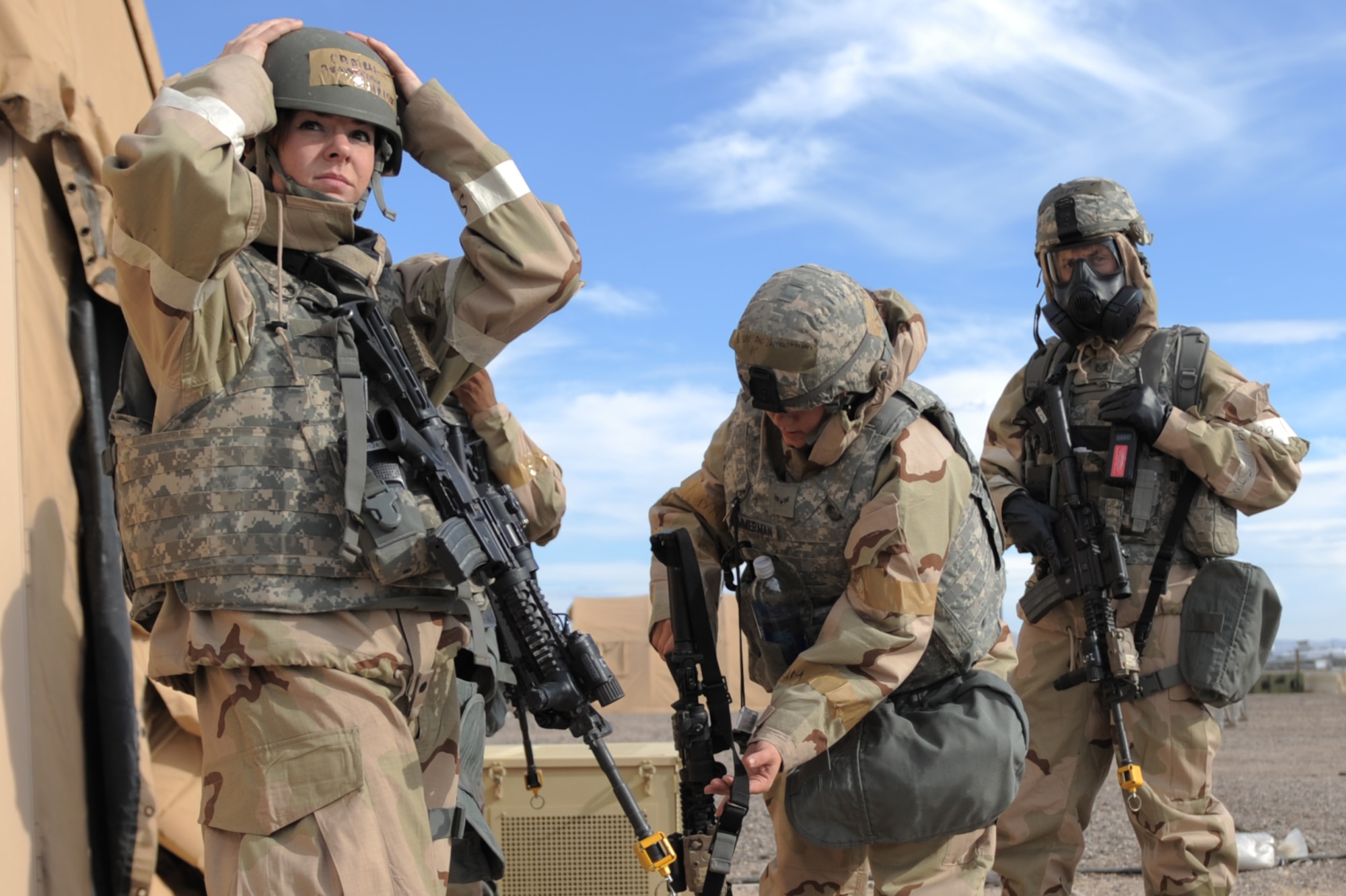 U.S. Air Force Airmen from the 355th Security Forces Squadron don Mission Oriented Protective Posture gear during an operational readiness exercise at Davis-Monthan Air Force Base, Ariz., Dec. 9, 2014. The ORE is intended to ensure DM Airmen maintain the highest levels of proficiency and readiness for worldwide military and humanitarian operations. (U.S. Air Force photo by Airman 1st Class Chris Drzazgowski/Released)