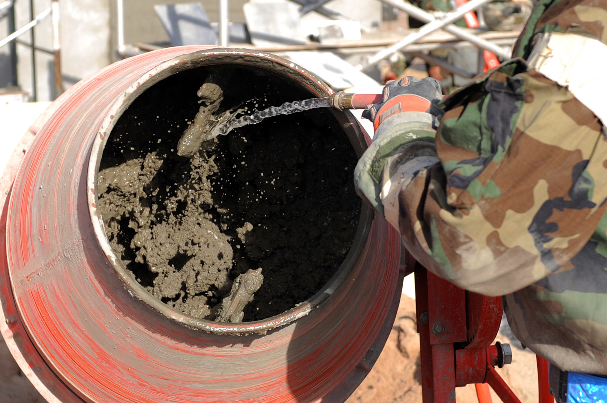 U.S. Air Force Senior Airman Gregory Lyles, 355th Civil Engineer Squadron heavy equipment operator, adds water to a stucco mixture during an operational readiness exercise at Davis-Monthan Air Force Base, Ariz., Dec. 9, 2014. The stucco was used as a durable and weather-resistant wall covering for the construction of a simulated command center. (U.S. Air Force photo by Airman 1st Class Chris Drzazgowski/Released) 