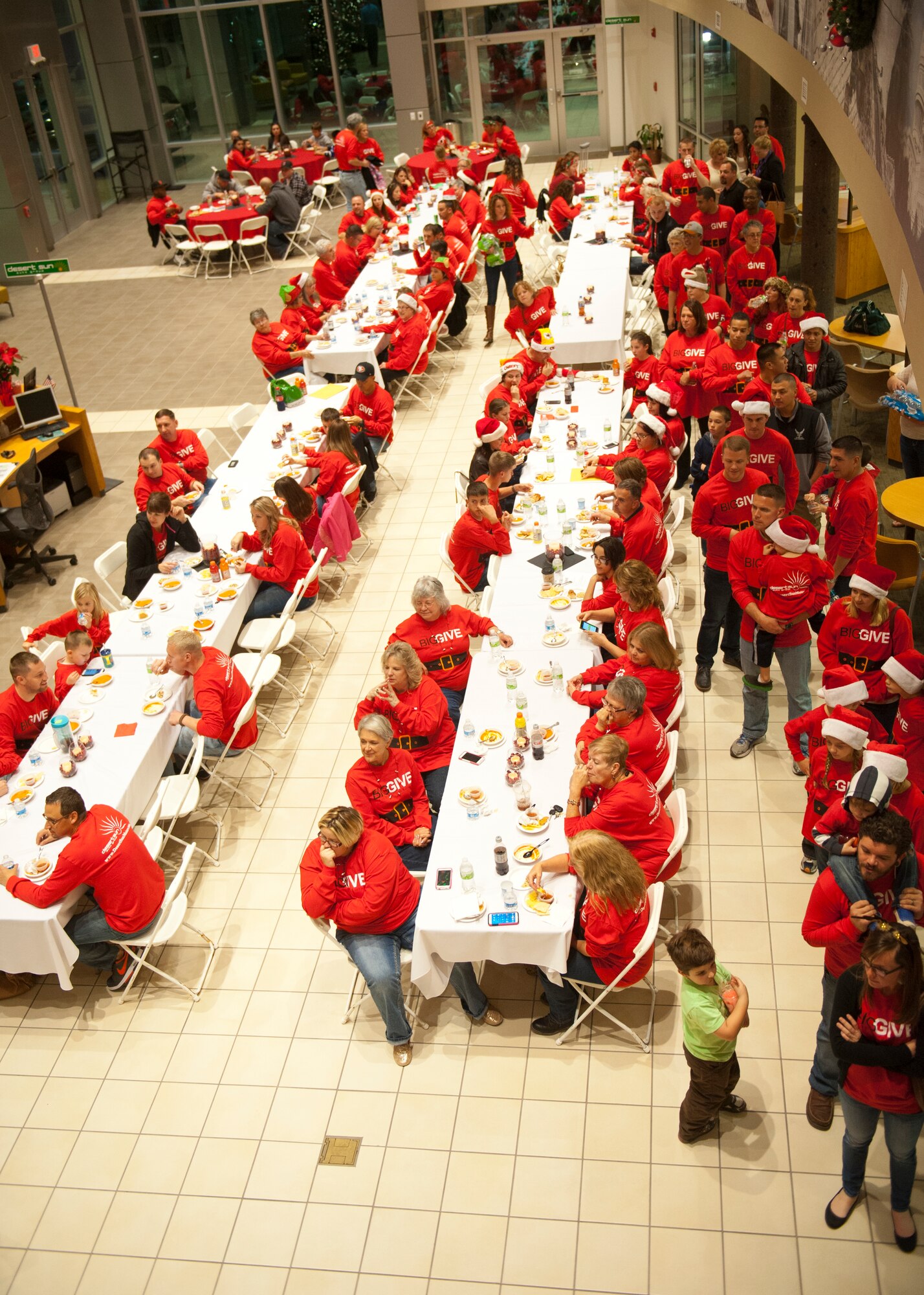 Participants from the Big Give Christmas Edition 2014 gather to eat and share their experiences from the event at Desert Suns Motors in Alamogordo, N.M., Dec. 9.  Each team selected a family to bless for the  holiday season, while additionally performing one random act of kindness to anyone they chose. This was the third annual Big Give Christmas event. (U.S. Air Force photo by Senior Airman Colin Cates/Released) 