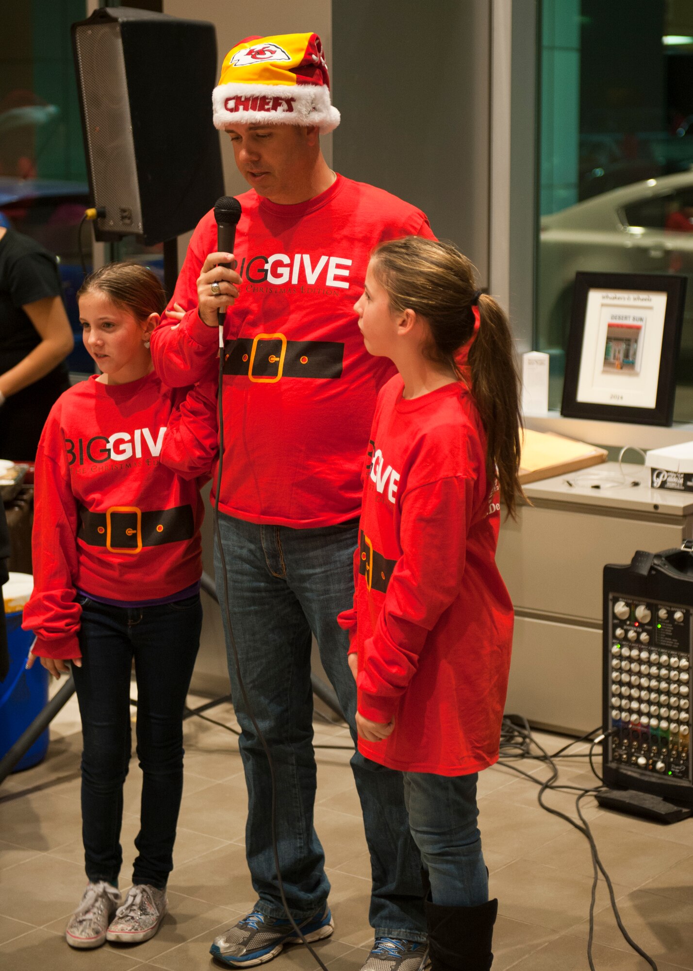 A participant from the Big Give Christmas Edition 2014 shares his story of giving at Desert Suns Motors in Alamogordo, N.M., Dec. 9. More than 250 volunteers showed up for the event, which made up 25 teams who all chose one family to give to. This was the third annual Big Give Christmas Edition. (U.S. Air Force photo by Senior Airman Colin Cates/Released)