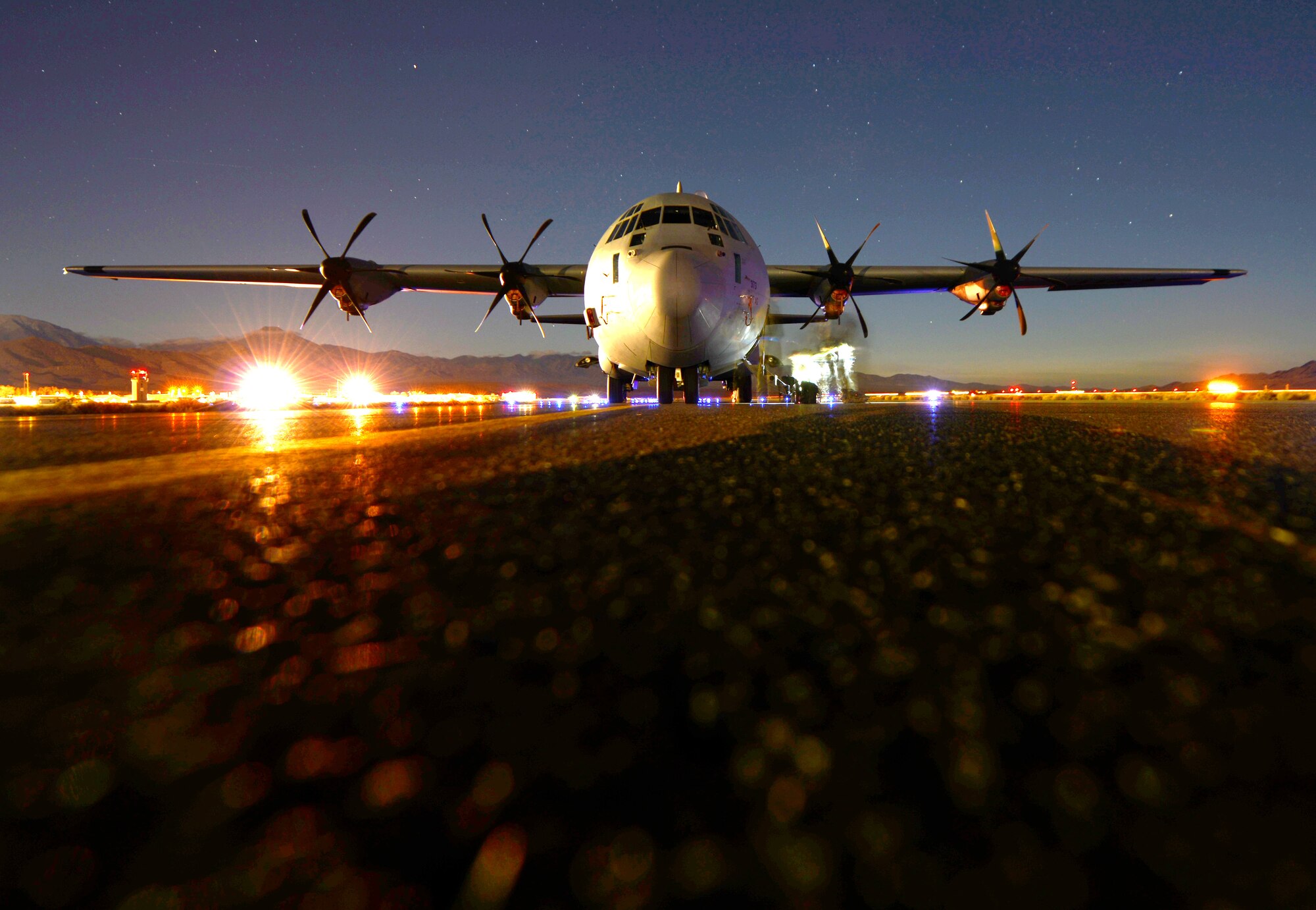 A C-130J Super Hercules assigned to the 317th Airlift Group is parked on the runway Dec. 6, 2014, at Creech Air Force Base, Nev. This aircraft, in addition to other J models and C-130Hs, with a combined total of more than 100 aircraft, participated in a joint forcible entry exercise, which included personnel drops, equipment drops and simulate seizure of enemy territory. (U.S. Air Force photo by Airman 1st Class Autumn Velez/Released)