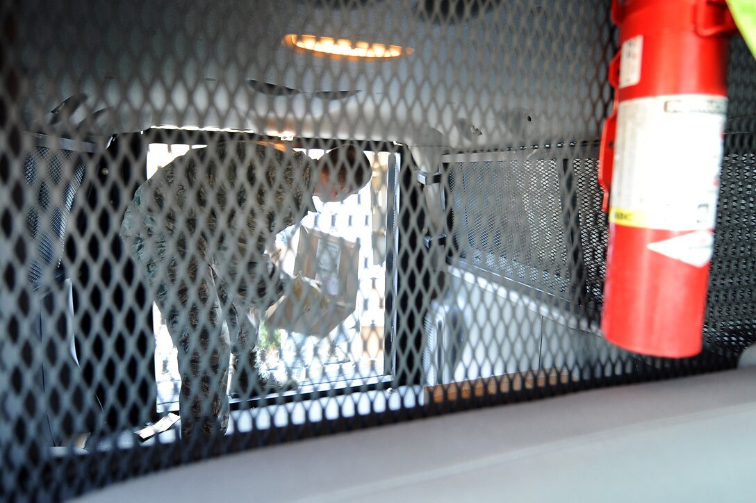 U.S. Air Force Staff Sgt. Derek Lamb, a Defense Courier Station Offutt courier, loads packages into a van outside of the courier station on Offutt Air Force Base, Neb., Dec. 8. Cargo is secured within the large metal cage of the van.  (U.S. Air Force photo by Josh Plueger/Released)