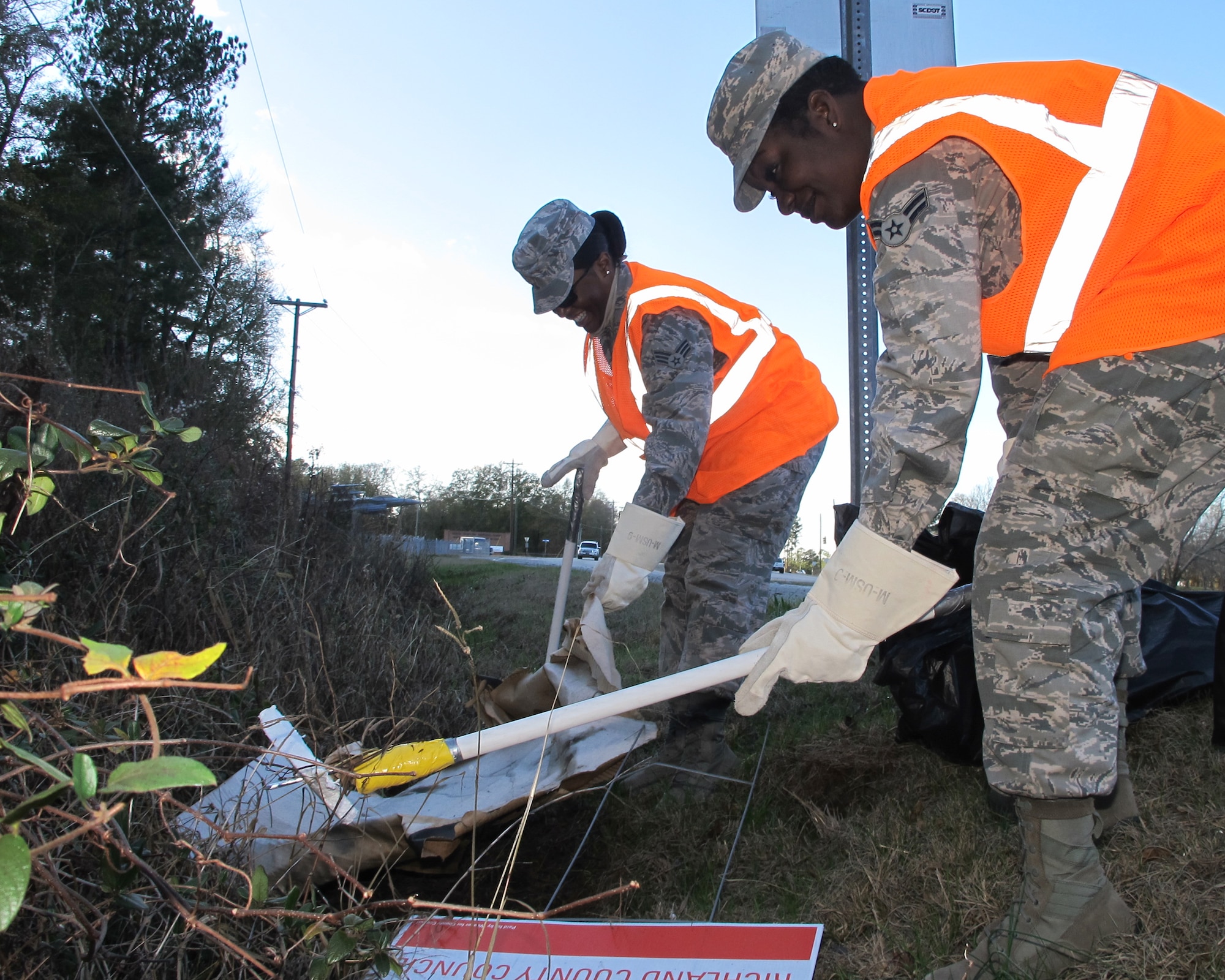 Senior Airman Renae McNease (left) and Airman 1st Class Angel Knox, emergency management technicians with the 169th Civil Engineer Squadron, pick up trash during an Adopt-a-Highway clean-up held Dec. 11, 2014. The South Carolina Air National Guard’s Environmental Office partners with the South Carolina Department of Transportation to pick up garbage outside of McEntire Joint National Guard Base four times a year and Airmen on base volunteer their efforts to keep the stretch of highway outside of the main gate clean.  (U.S. Air National Guard photo by 2nd Lt. Stephen Hudson/Released)