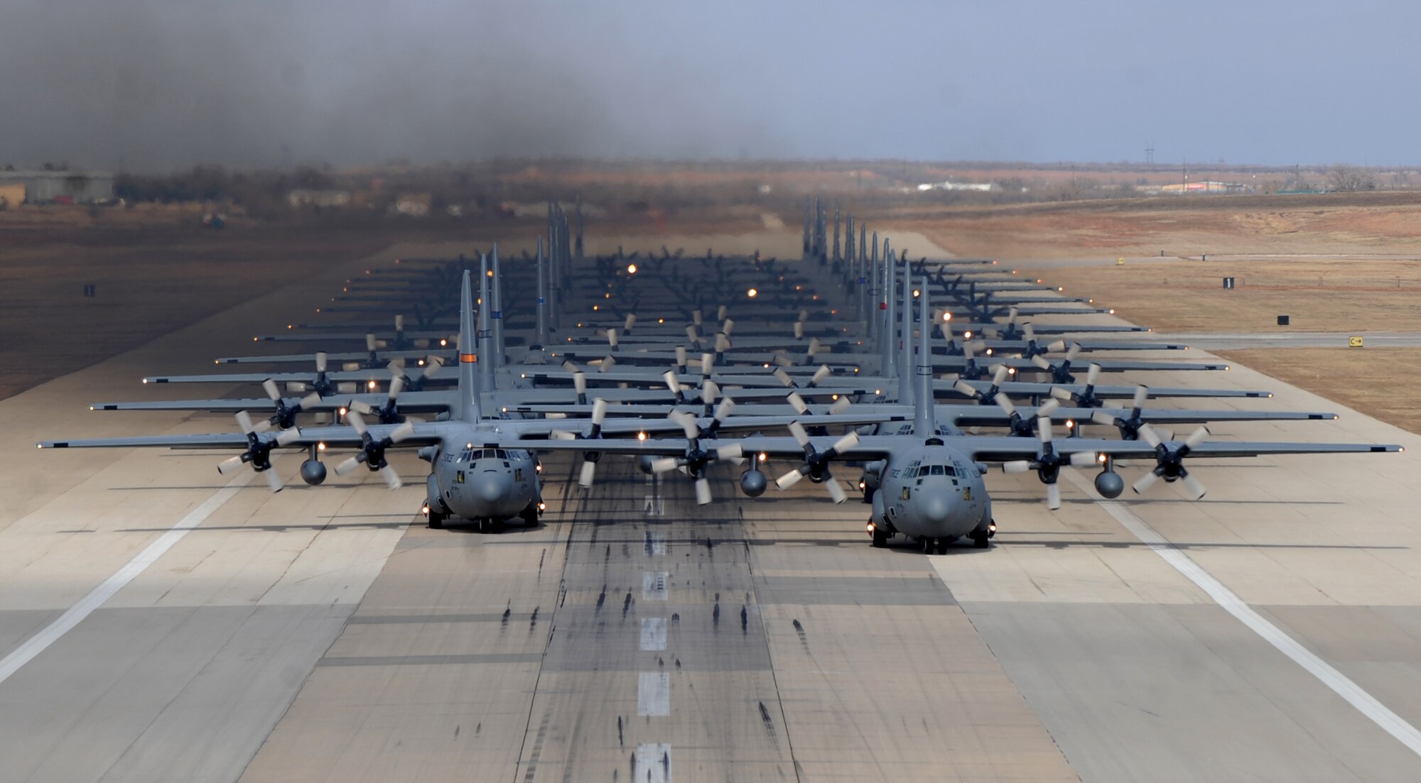 Eleven C-130H Hercules’ from various Air National Guard units and thirteen C-130J Super Hercules’ from the 317th Airlift Group at Dyess Air Force Base, Texas, prepare to take off from Dyess AFB in support of the U.S. Air Force Weapons School's Joint Forcible Entry Exercise 14B Dec. 6, 2014. In addition to the C-130s, the JFEX included approximately 20 C-17 Globemaster IIIs and various other aircraft. (U.S. Air Force photo by Airman 1st Class Alexander Guerrero/Released)