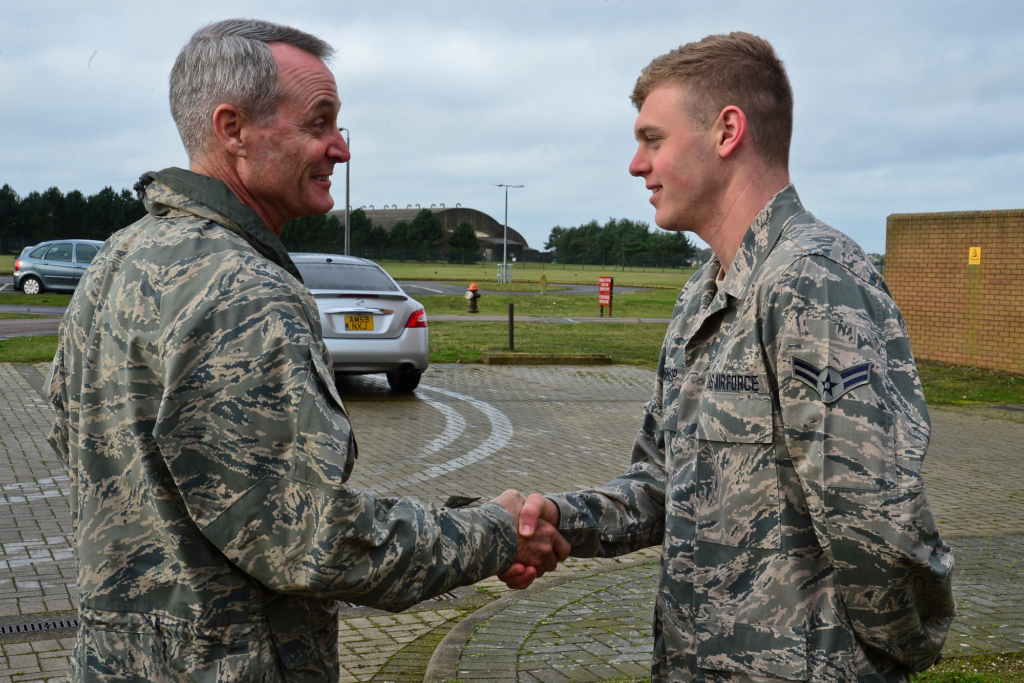 Lt. Gen. Darryl Roberson, 3rd Air Force and 17th Expeditionary Air Force commander, coins Airman 1st Class Justin Bishop, 48th Operations Support Squadron aircrew flight equipment journeyman, at Royal Air Force Lakenheath, England, Nov. 13, 2014, for superior performance. Bishop was nominated for a Liberty Spotlight because he embodies the core value of Excellence in All We Do. (U.S. Air Force photo by Airman 1st Class Erin R. Babis/Released)