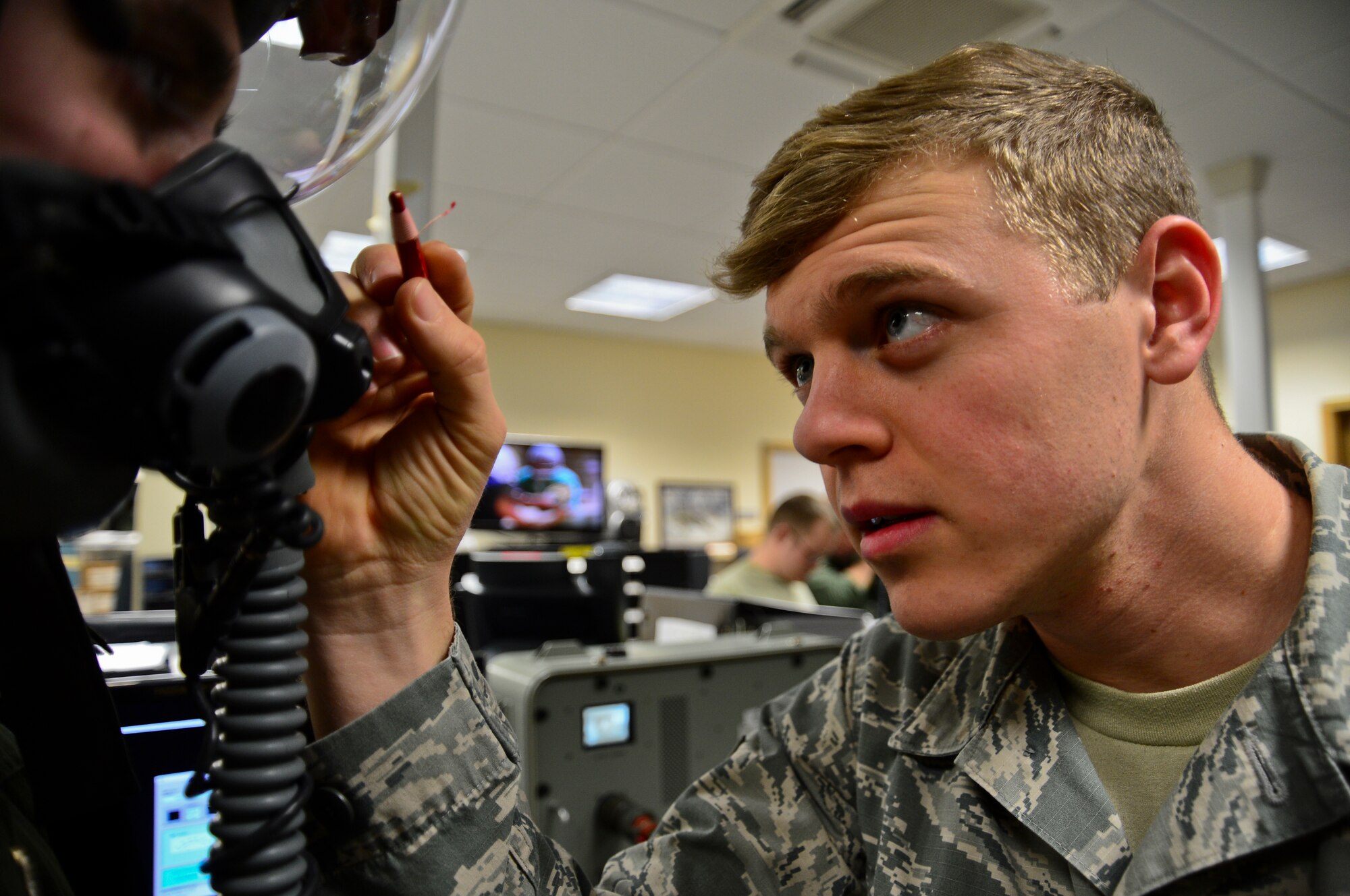 Airman 1st Class Justin Bishop, 48th Operations Support Squadron aircrew flight equipment journeyman, marks a pilot's visor for a custom fit at Royal Air Force Lakenheath, England, Dec. 11, 2014. Bishop was nominated for a Liberty Spotlight because he embodies the core value of Excellence in All We Do. (U.S. Air Force photo by Airman 1st Class Erin R. Babis/Released)
