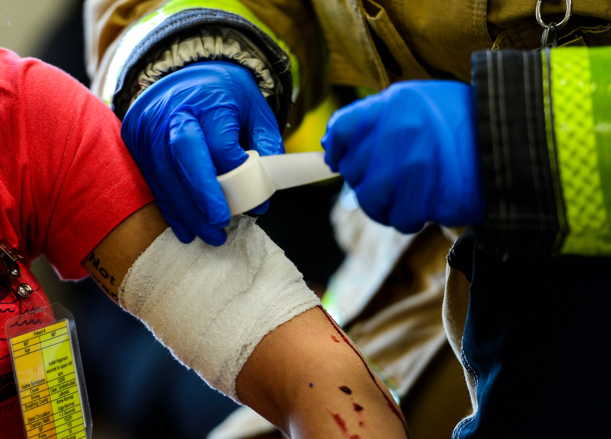 A U.S. Air Force first responder dresses a wound on a simulated victim during an active shooter exercise at Langley Air Force Base, Va., Dec. 11, 2014. The exercise tested the abilities of first responders to quickly and efficiently respond to a real-world threat.  (U.S. Air Force photo by Senior Airman Kayla Newman/Released)