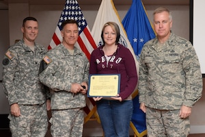 U.S. Army Lt. Col Bartholomew Hennessey, Initial Military Training secretary of the general staff; Col. William Galbraith, 733rd Mission Support Group commander, and U.S. Air Force Col. John J. Allen, Jr., 633rd Air Base Wing commander, far right, recognize Alicia Harrell, 359th Transportation Company, 10th Transportation Battalion, 7th Transportation Brigade (Expeditionary) family readiness group leader, during a Volunteer of the Quarter ceremony at Fort Eustis, Va., Nov. 18, 2014. FRG leaders can volunteer up to 200 hours each month coordinating events and supporting families of deployed U.S. Soldiers. (U.S. Air Force photo by Staff Sgt. Teresa J. Cleveland/Released)