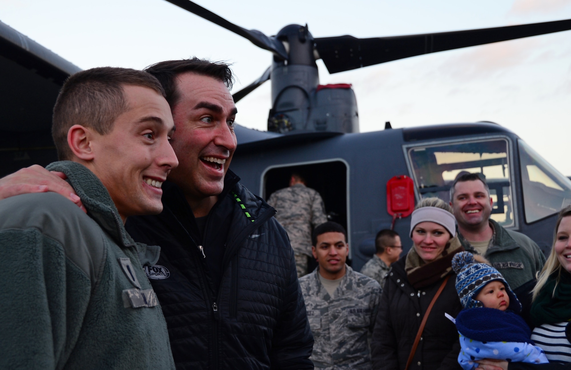 An Airman assigned to the 100th Air Refueling Wing poses for a picture with Rob Riggle, actor and comedian, during a USO Holiday Troop Visit at Royal Air Force Mildenhall, England, Dec. 10, 2014. Riggle toured with five other celebrities and the Chairman of the Joint Chiefs of Staff to various overseas bases to bring holiday cheer to Airmen serving abroad. (U.S. Air Force photo by Senior Airman Erin O’Shea/Released)