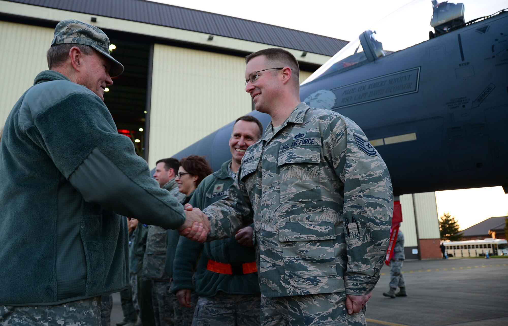 Army Gen. Martin E. Dempsey, 18th Chairman of the Joint Chiefs of Staff, coins Tech. Sgt. Scott Douglass, 48th Equipment Maintenance Squadron assistant flight chief, during a USO Holiday Troop Visit at Royal Air Force Mildenhall, England, Dec. 10, 2014. The visit is a tradition in which the USO partners with senior leaders and celebrity entertainers to visit troops serving abroad during the holiday season.  (U.S. Air Force photo by Senior Airman Erin O’Shea/Released)