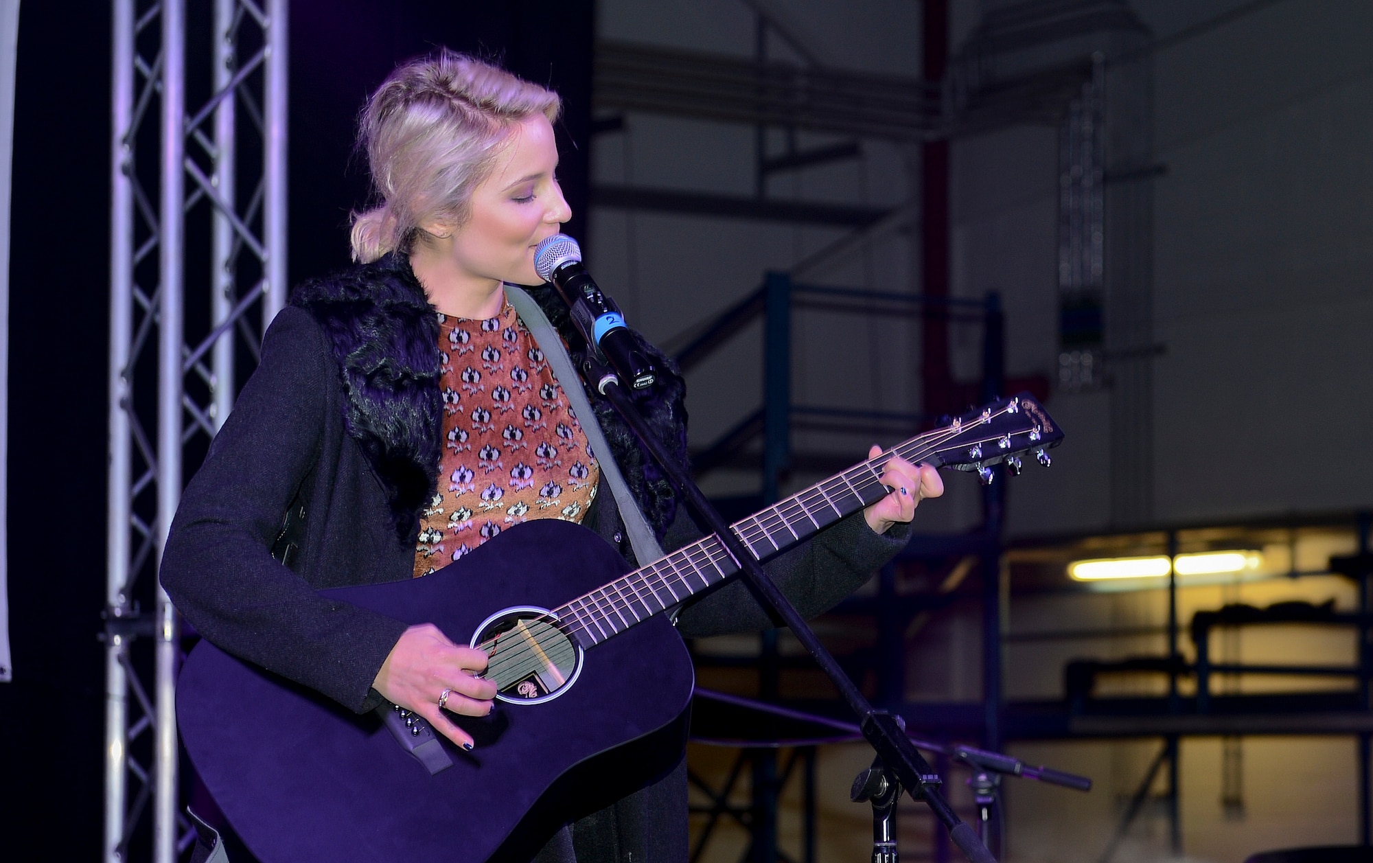 Dianna Agron, singer and actress, performs for audience members during a USO holiday Troop Visit at Royal Air Force Mildenhall, England, Dec. 10, 2014. Agron toured with five other celebrities and the Chairman of the Joint Chiefs of Staff to various overseas bases to bring holiday cheer to service members serving abroad. (U.S. Air Force photo by Airman 1st Class Trevor T. McBride/Released)
