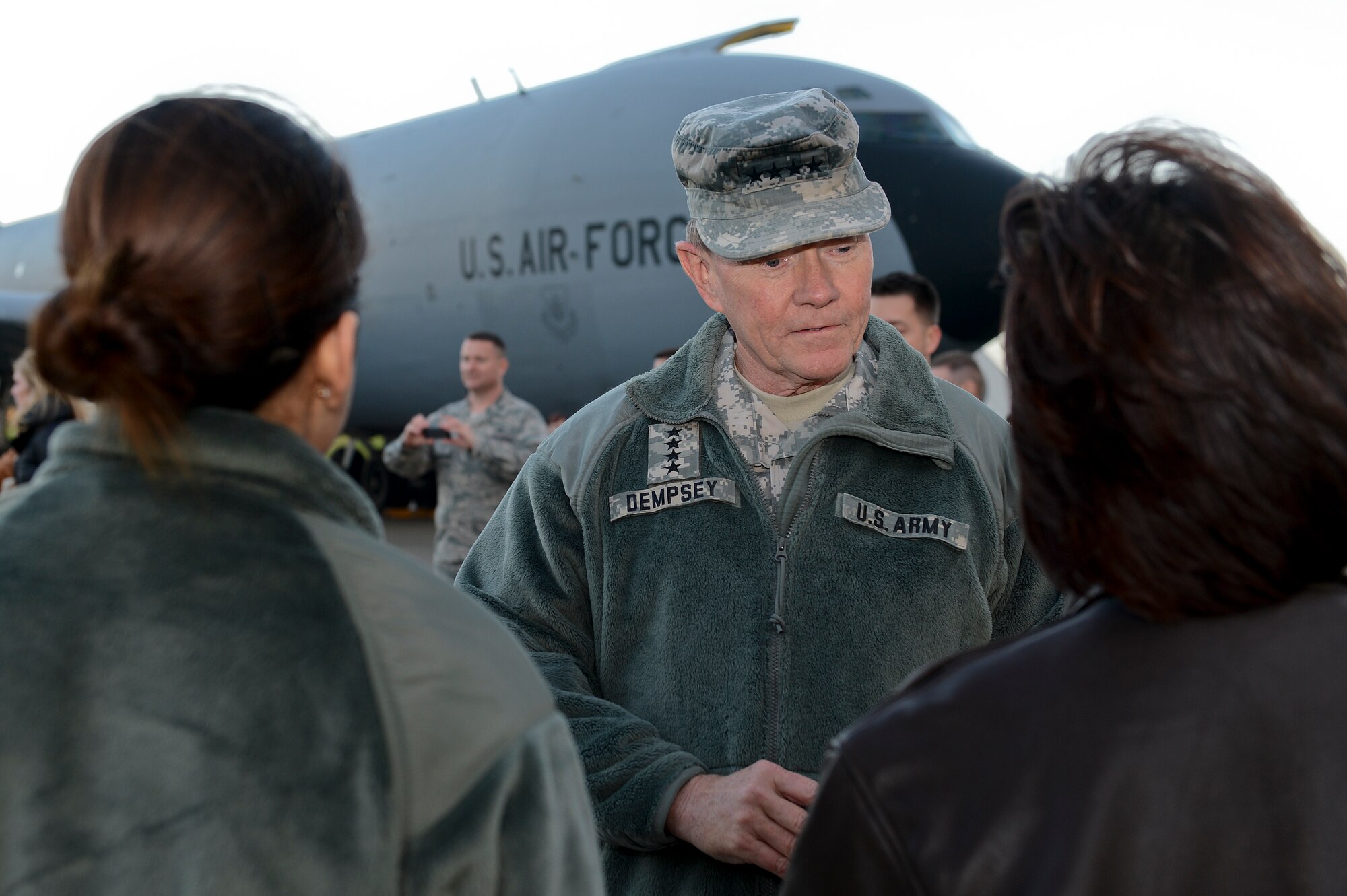 Army Gen. Martin E. Dempsey, 18th Chairman of the Joint Chiefs of Staff, meets Air Force Col. Lynda Vu, 48th Aerospace Medical Squadron commander, at a coining ceremony during a USO Holiday Troop Visit to Royal Air Force Mildenhall, England, Dec. 10, 2014. The visit is a tradition in which the USO partners with senior leaders and celebrity entertainers to see troops serving abroad during the holidays. (U.S. Air Force photo by Airman 1st Class Trevor T. McBride/Released)