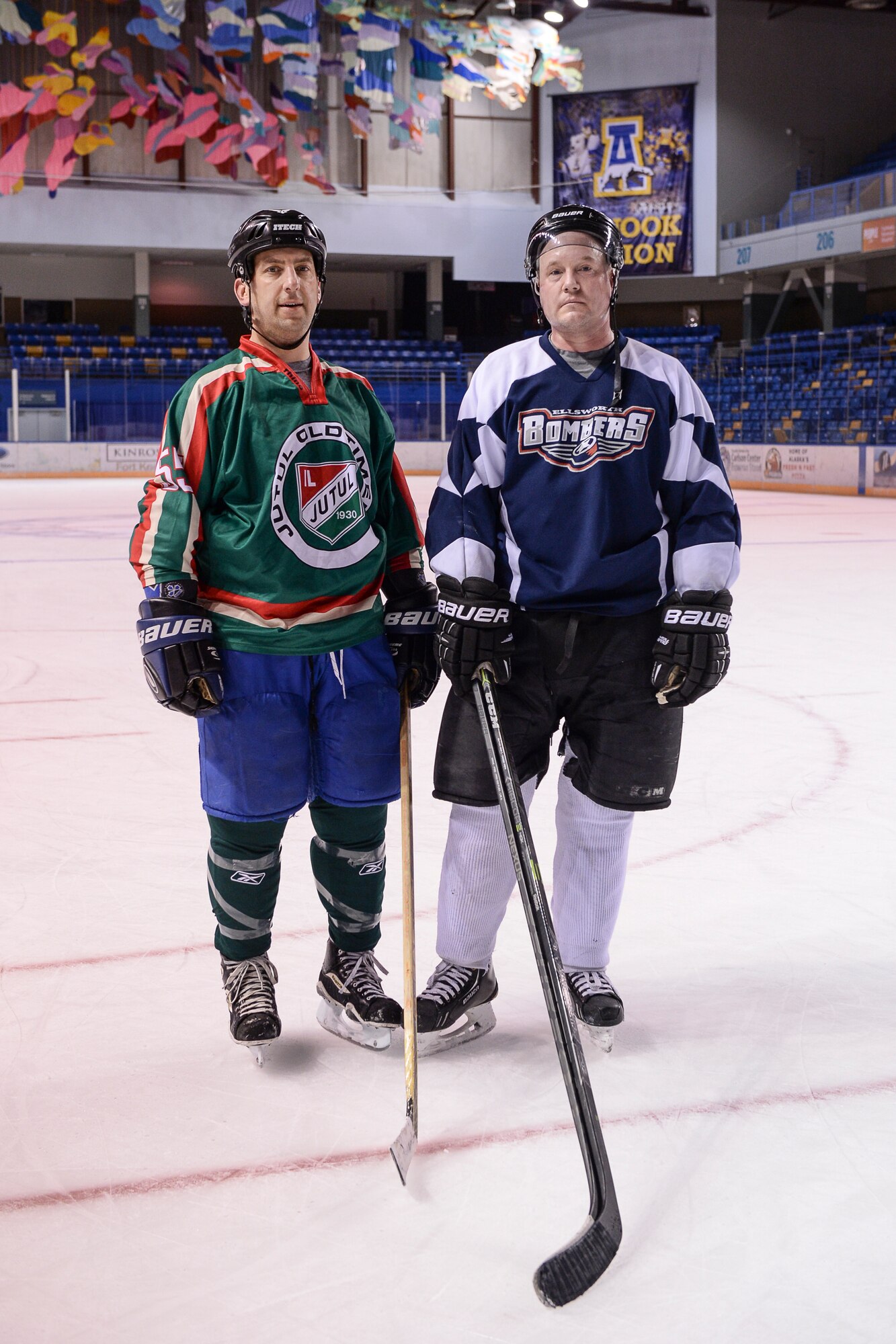 U.S. Air Force Lt. Col. David Michaud, the 353rd Combat Training Squadron commander, and retired Master Sgt. Chris Malenius, both Eielson Air Force Base hockey team defensemen, pause for a photo Nov. 23, 2014, after a team practice in  Fairbanks, Alaska. Michaud and Malenius recently discovered they used to play against each other during youth hockey in Northern Minnesota. (U.S. Air Force photo by Senior Airman Peter Reft/Released)