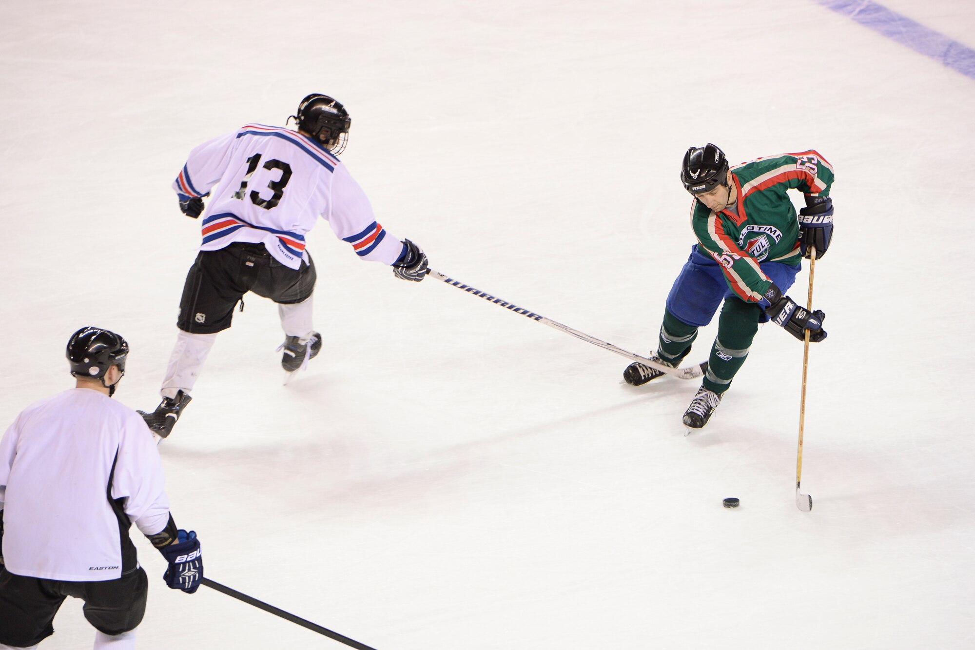 U.S. Air Force Lt. Col. David Michaud, the 353rd Combat Training Squadron commander, evades opposing players Nov. 23, 2014, during practice in  Fairbanks, Alaska. Michaud discovered one of his teammates on Eielson's hockey team, retired Master Sgt. Chris Malenius, was a regular opponent from his youth hockey league in their Northern Minnesota hometown. (U.S. Air Force photo by Senior Airman Peter Reft/Released)