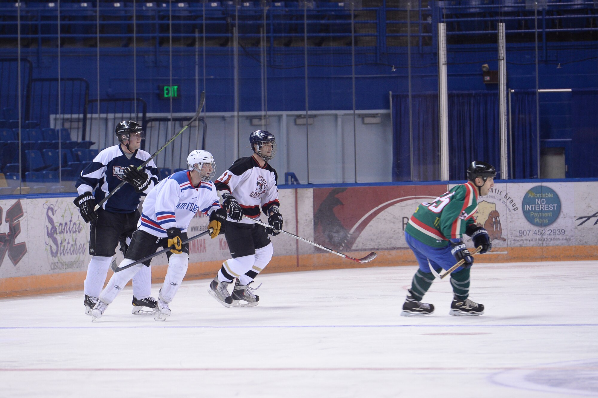 U.S. Airmen on the Eielson Air Force Base hockey team chase the puck Nov. 23, 2014, during practice in Fairbanks, Alaska. Eielson's hockey team was preparing for the upcoming 2014 Commander's Cup game at the Carlson Center against players from Fort Wainwright. (U.S. Air Force photo by Senior Airman Peter Reft/Released)