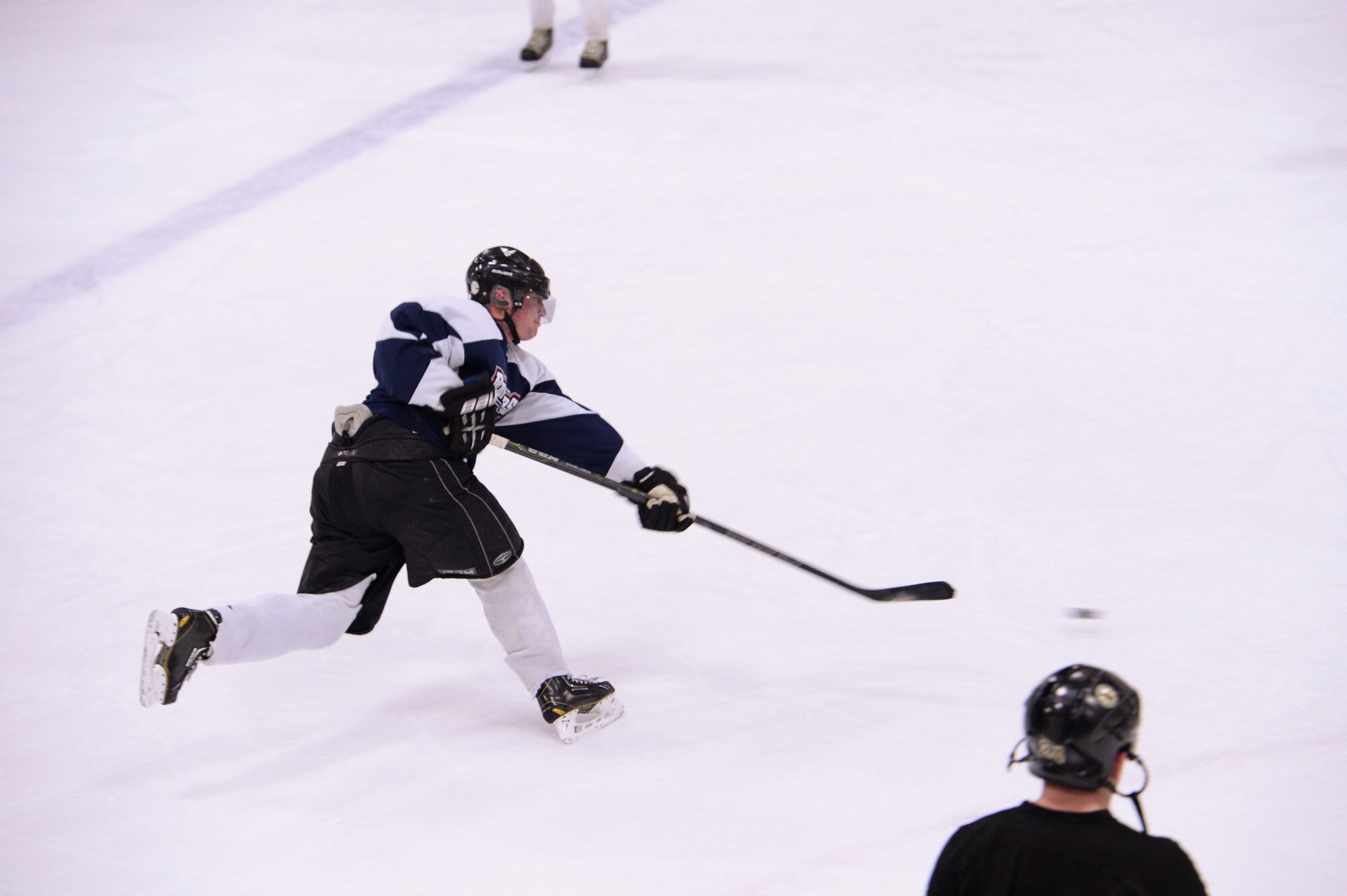 Retired U.S. Air Force Master Sgt. Chris Malenius, Eielson Air Force Base hockey team defenseman, takes a shot on goal Nov. 18, 2014, during practice at Fort Wainwright, Alaska. Eielson's hockey team was preparing for the upcoming 2014 Commander's Cup game at the Carlson Center against players from Fort Wainwright. (U.S. Air Force photo by Senior Airman Peter Reft/Released)