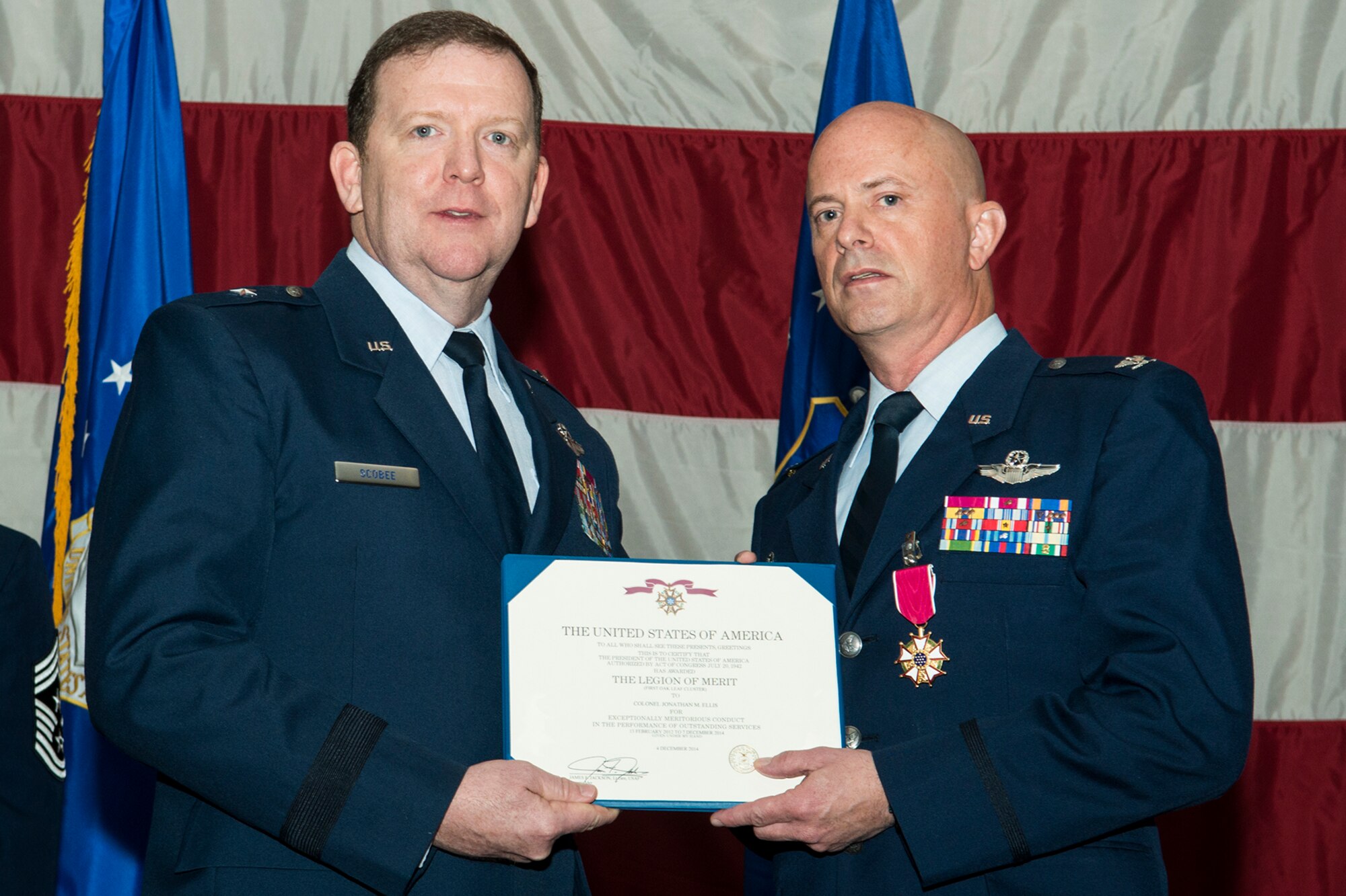 U.S. Air Force Brig. Gen. Richard Scobee, 10th Air Force commander, presents the Legion of Merit to Col. Jonathan Ellis during a 307th Bomb Wing (BW) Change of Command Ceremony, Dec. 7, 2014, Barksdale Air Force Base, La. Ellis received the award for exceptionally meritorious conduct in the performance of outstanding service to the United States as Commander of the 307th BW from Feb. 13, 2012 to Dec. 7, 2014. (U.S. Air Force photo by Master Sgt. Greg Steele/Released)