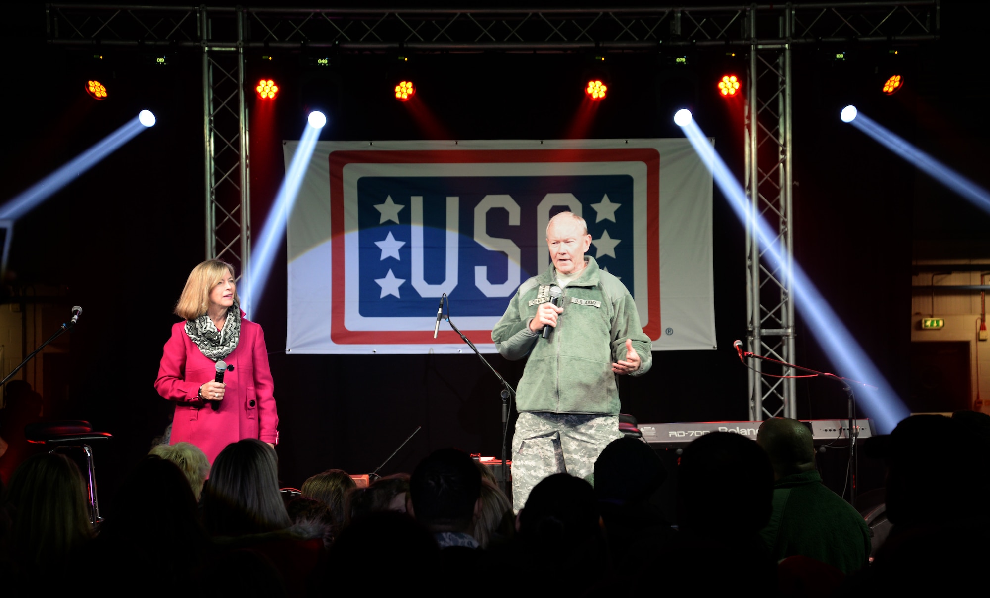 U.S. Army Gen. Martin E. Dempsey, Chairman of the Joint Chiefs of Staff, right, and his wife Deanie, speak to attendees of a USO holiday tour Dec. 10, 2014, on RAF Mildenhall, England. Dempsey introduced the celebrities who accompanied him to the base before their performances started. (U.S. Air Force photo by Airman 1st Class Dillon Johnston/Released)