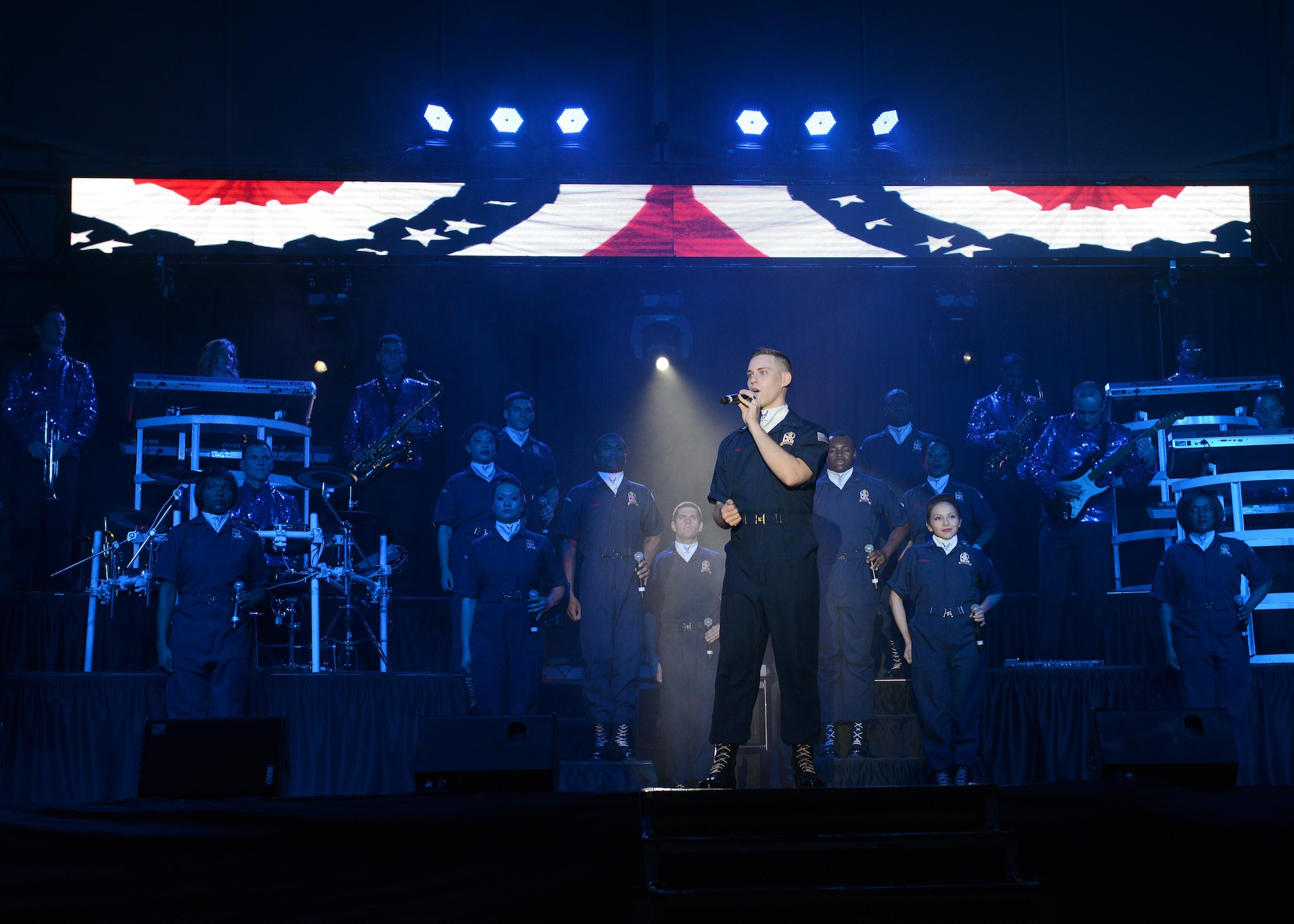 Senior Airman Jeremiah Barnes, Tops in Blue male vocalist, sings the traditional rendition of “God Bless America” during a TIB performance, Dec. 9, 2014, at Aviano Air Base, Italy. Annually TIB looks for female and male vocalist, instrumentalists, dancers and non-musical performers to tour and entertain military installations. (U.S. Air Force photo/Airman 1st Class Deana Heitzman)