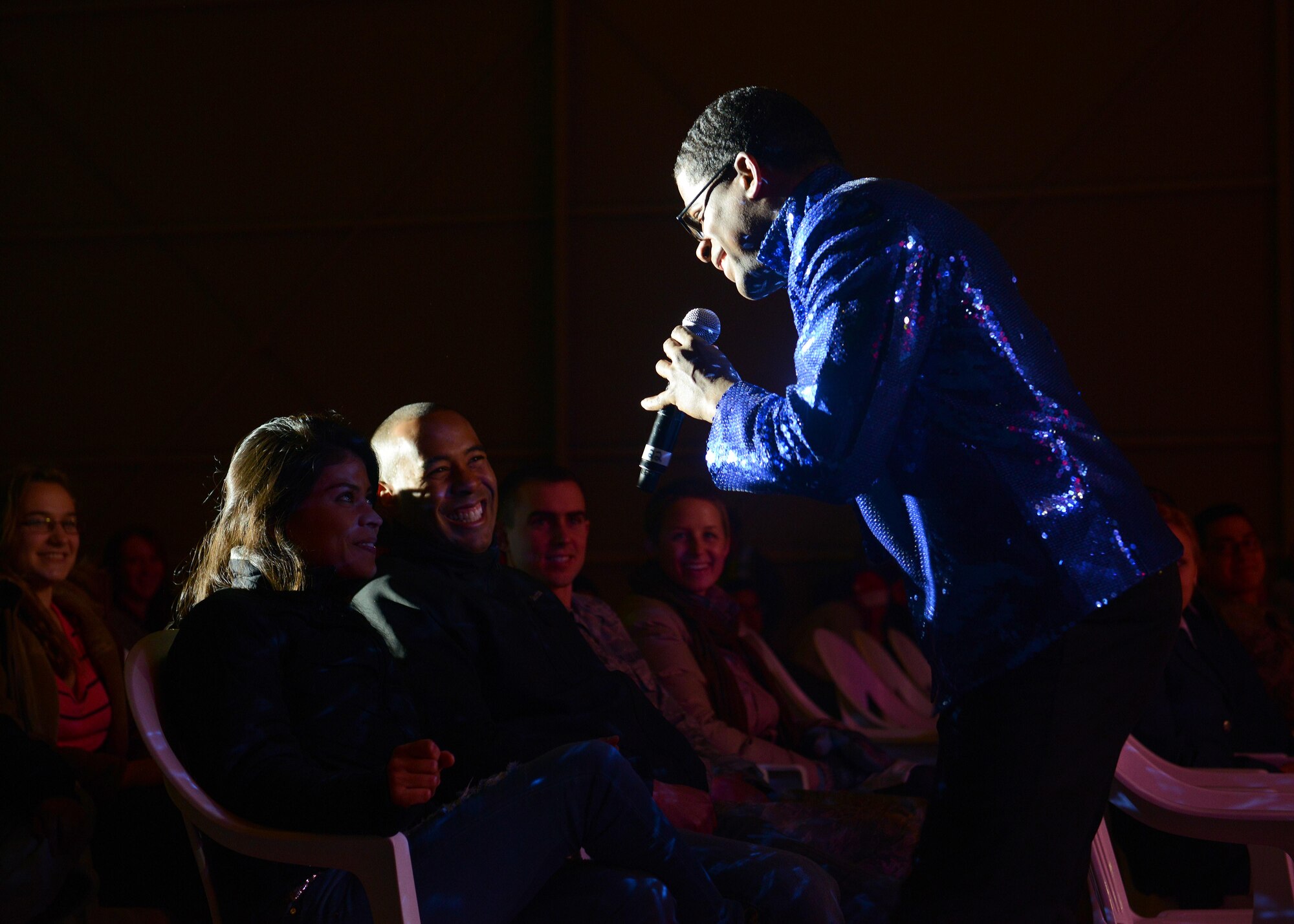 Staff Sgt. Marc Hightower, Tops in Blue male vocalist, sings to a member in the audience during a TIB performance, Dec. 9, 2014, at Aviano Air Base, Italy. This year, TIB toured more than 50 military installations in more than 10 countries to provide entertainment to service members and their families. (U.S. Air Force photo/Airman 1st Class Deana Heitzman)
