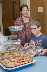 Eva Chambers and her son, Elijah, donate cookies during Operation Cookie Drop Dec. 10 at Joint Base San Antonio-Randolph’s Chapel One Kitchen Annex. The event was a combined effort from the local community and base population to bring homemade cookies to Airmen and provide a taste of home during the holiday season to all the single Airmen assigned to JBSA-Randolph. (U.S. Air Force photo by Johnny Saldivar)