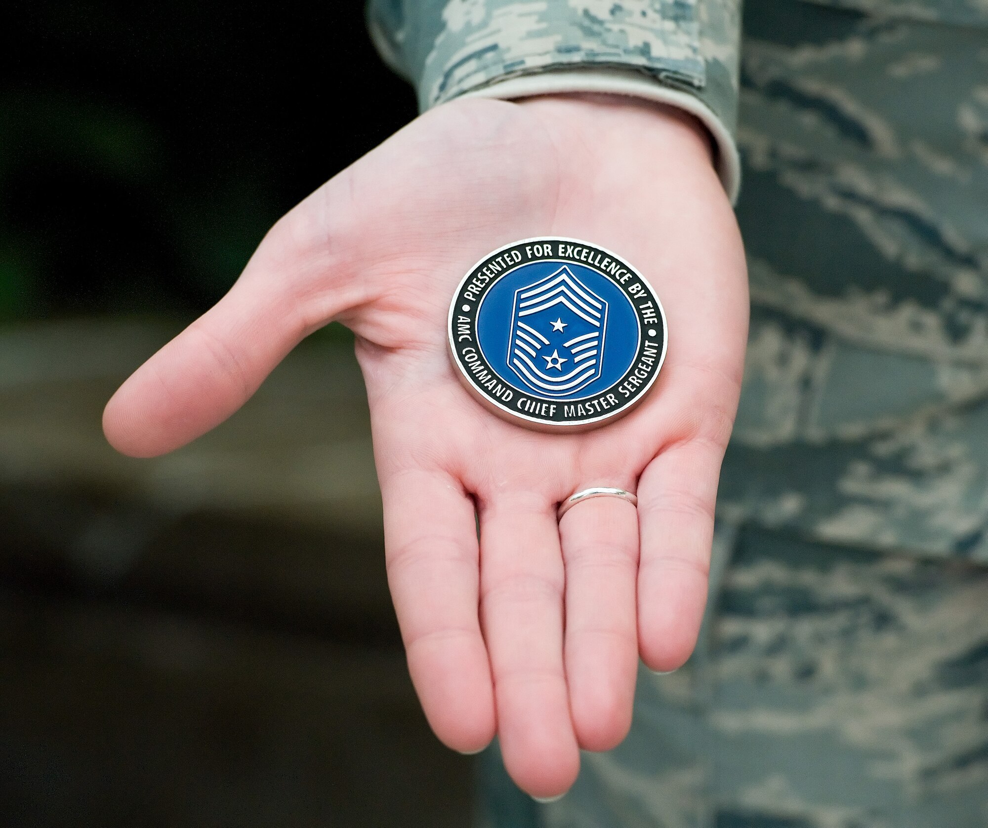 Senior Airman Katie Young, Air Force Mortuary Affairs Operations dress and restoration section, holds the coin Chief Master Sgt. Victoria Gamble, Air Mobility Command chief presented to her Dec. 4, 2014, at the Charles C. Carson Center for Mortuary Affairs, Dover Air Force Base, Del. Young, who is assigned to the 436th Force Support Squadron, Dover AFB, is deployed to AFMAO in support of the mortuary mission. (U.S. Air Force photo/Roland Balik)