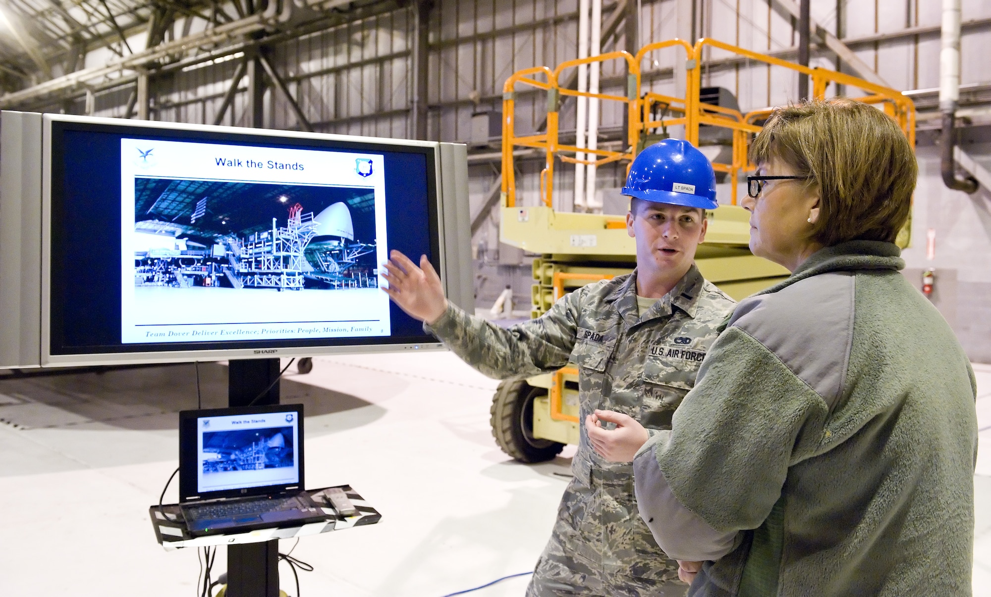 First Lt. Joseph Spada, 436th Maintenance Squadron isochronal inspection officer in charge, briefs Chief Master Sgt. Victoria Gamble, Air Mobility Command chief, right, about the C-5 isochronal inspection process Dec. 4, 2014, on Dover Air Force Base, Del. Gamble received a tour of the inspection facility and met with some of the workers performing maintenance on a C-5A Galaxy. (U.S. Air Force photo/Roland Balik)