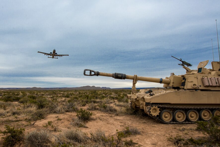 U.S. Air Force Maj. Zach Laird, 23d Fighter Group chief of standards and evaluation, executes a show-of-force maneuver in an A-10C Thunderbolt II over an M109A6 Paladin howitzer Dec. 4, 2014, at the Oro Grande Range Complex, Fort Bliss, Texas. While supporting artillery units, A-10 pilots must continuously ‘deconflict,’ ensuring they stay out of the line of friendly-fire, while also attacking their target. (U.S. Air Force Photo by Airman 1st Class Ryan Callaghan/Released)
