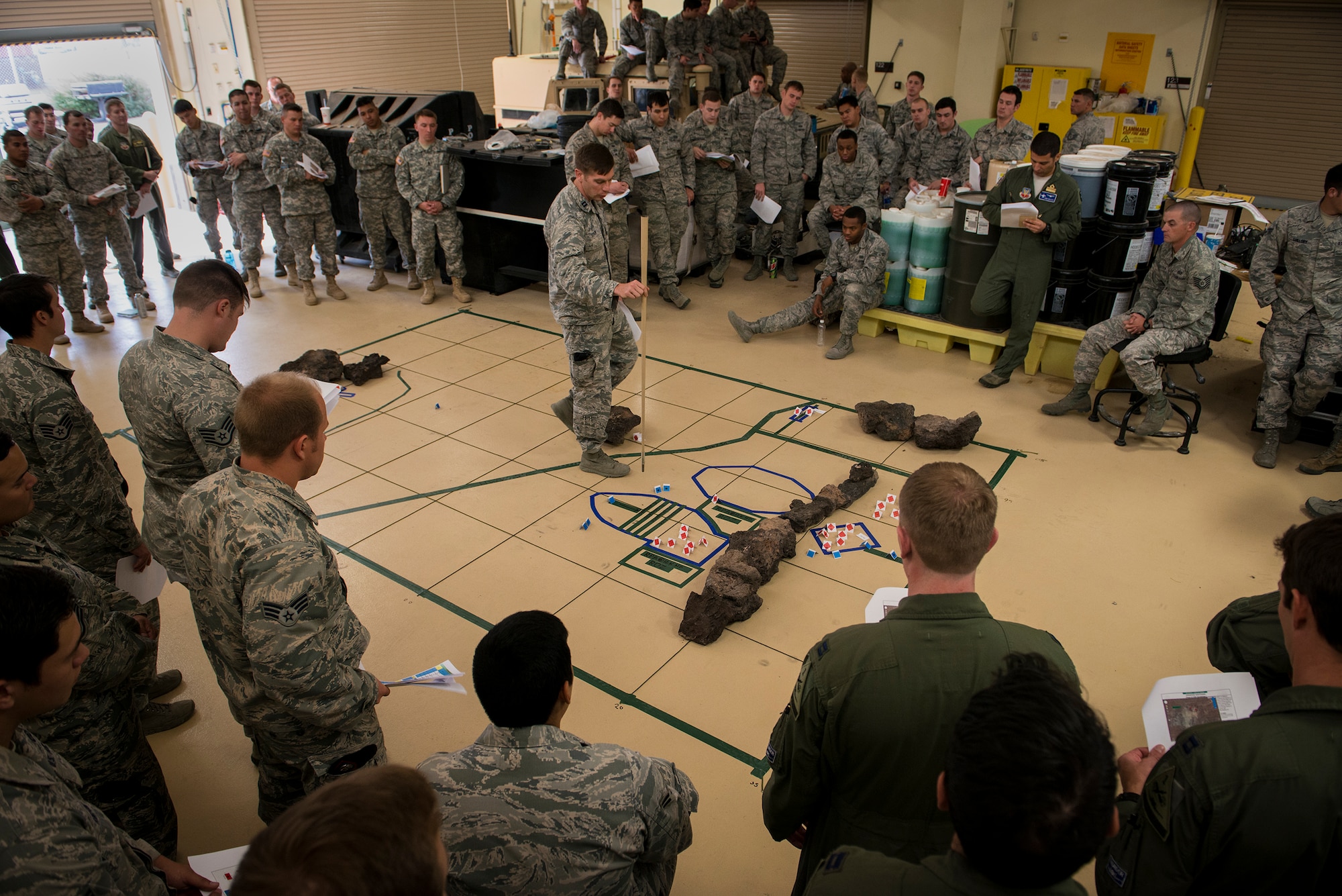 U.S. Air Force Capt. Kyle Spain, 7th Air Support Operations Squadron executive officer, runs through a fire-support rehearsal on a terrain model, Dec. 2, 2014, at Fort Bliss, Texas. A fire-support rehearsal gives pilots a heightened awareness of where ground troops will be in relation to natural landmarks such as ridges and roadways. (U.S. Air Force Photo by Airman 1st Class Ryan Callaghan/Released)