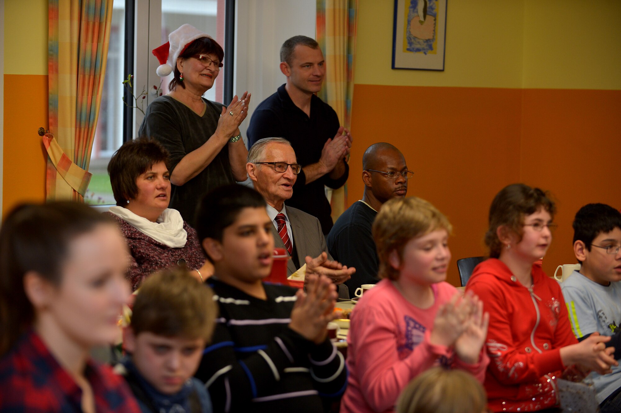 U.S. Air Force Airmen and civilians from Spangdahlem Air Base, Germany, sing carols with children from St. Martin School in Bitburg, Germany, Dec. 8, 2014. Gifts were presented to the children by the 52nd Civil Engineer Squadron leadership, who raise funds each year to support the school. (U.S. Air Force photo by Airman 1st Class Kyle Gese/Released)
