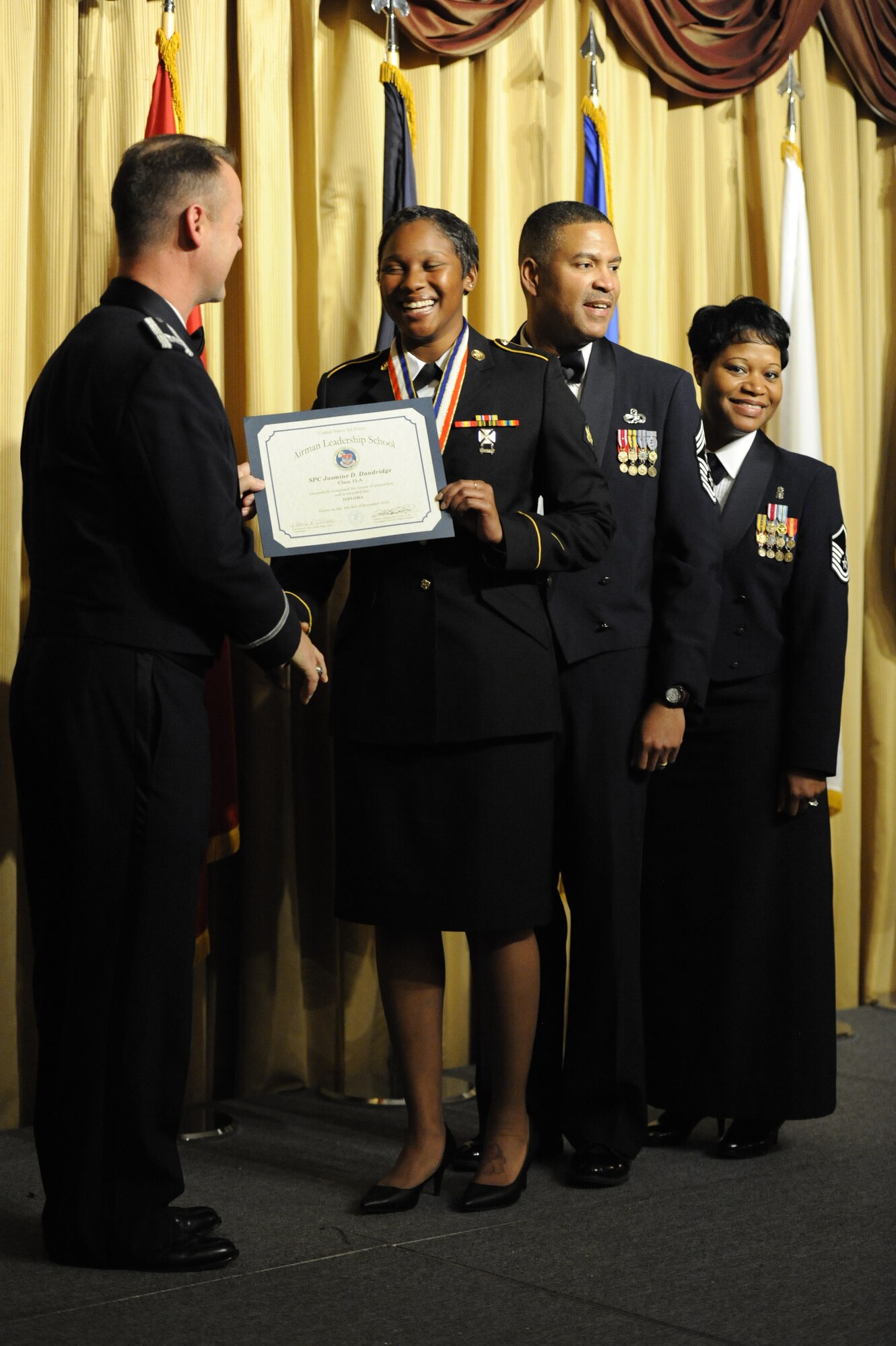 Spc. Jasmine Dandridge, 77th Sustainment Brigade material manager and Athens, Ga., native, receives her graduation certificate at the Kish Airman Leadership School graduation Dec. 4, 2014, at Joint Base McGuire-Dix-Lakehurst, N.J. Dandridge is the first Soldier to graduate the six-and-a-half week Kish ALS course. (U.S. Air Force photo by Airman 1st Class Sean M. Crowe/Released)